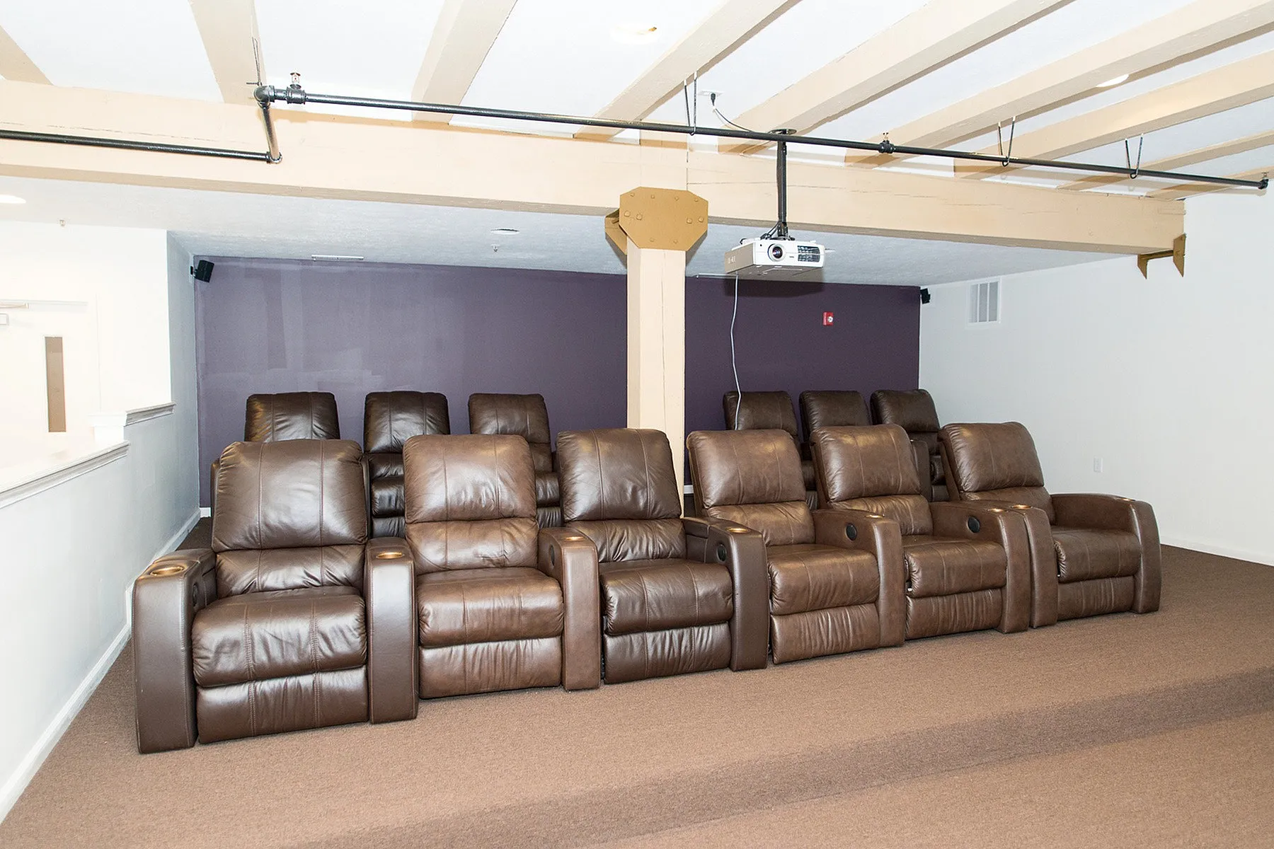 Luxurious in-home theater with plush leather reclining chairs and a modern projector setup, perfect for entertainment enthusiasts.