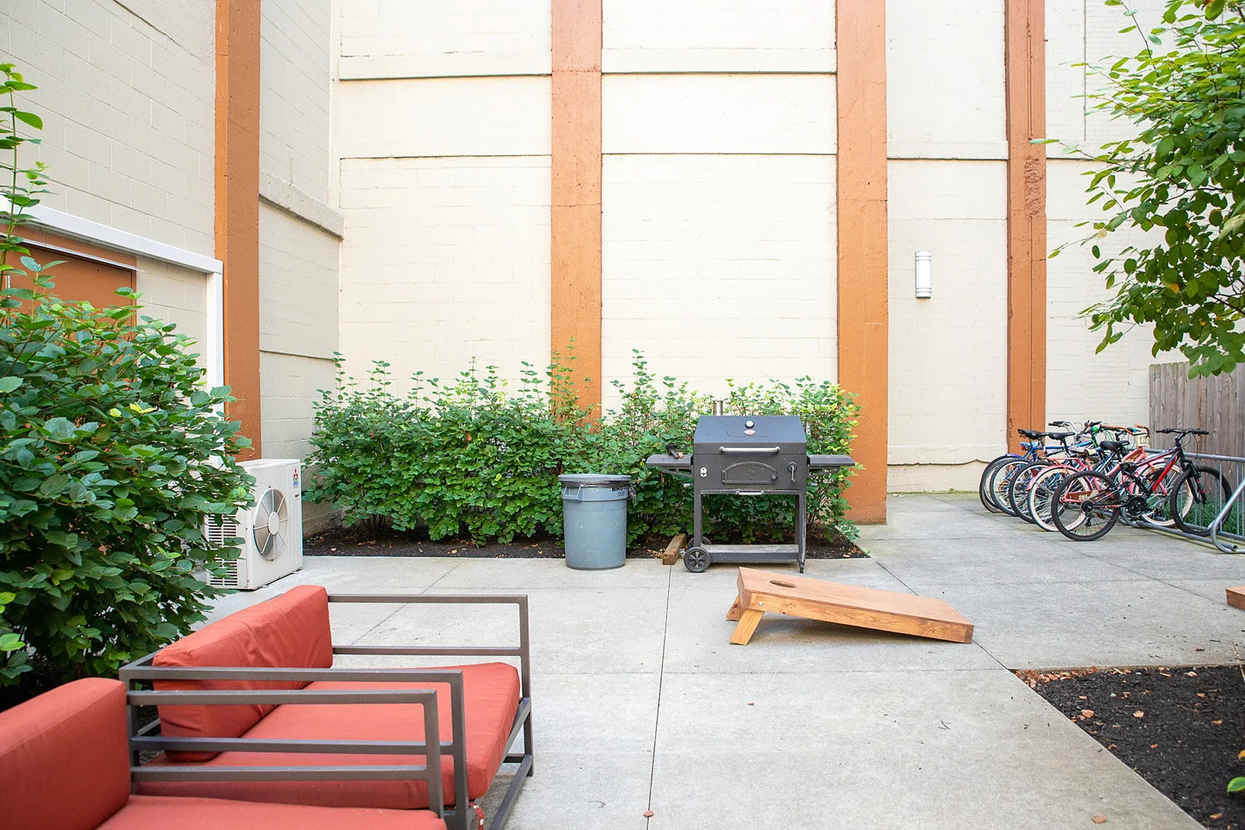 Charming outdoor patio with cozy seating, a barbecue grill, and a neatly arranged bike area, perfect for relaxation and casual gatherings.