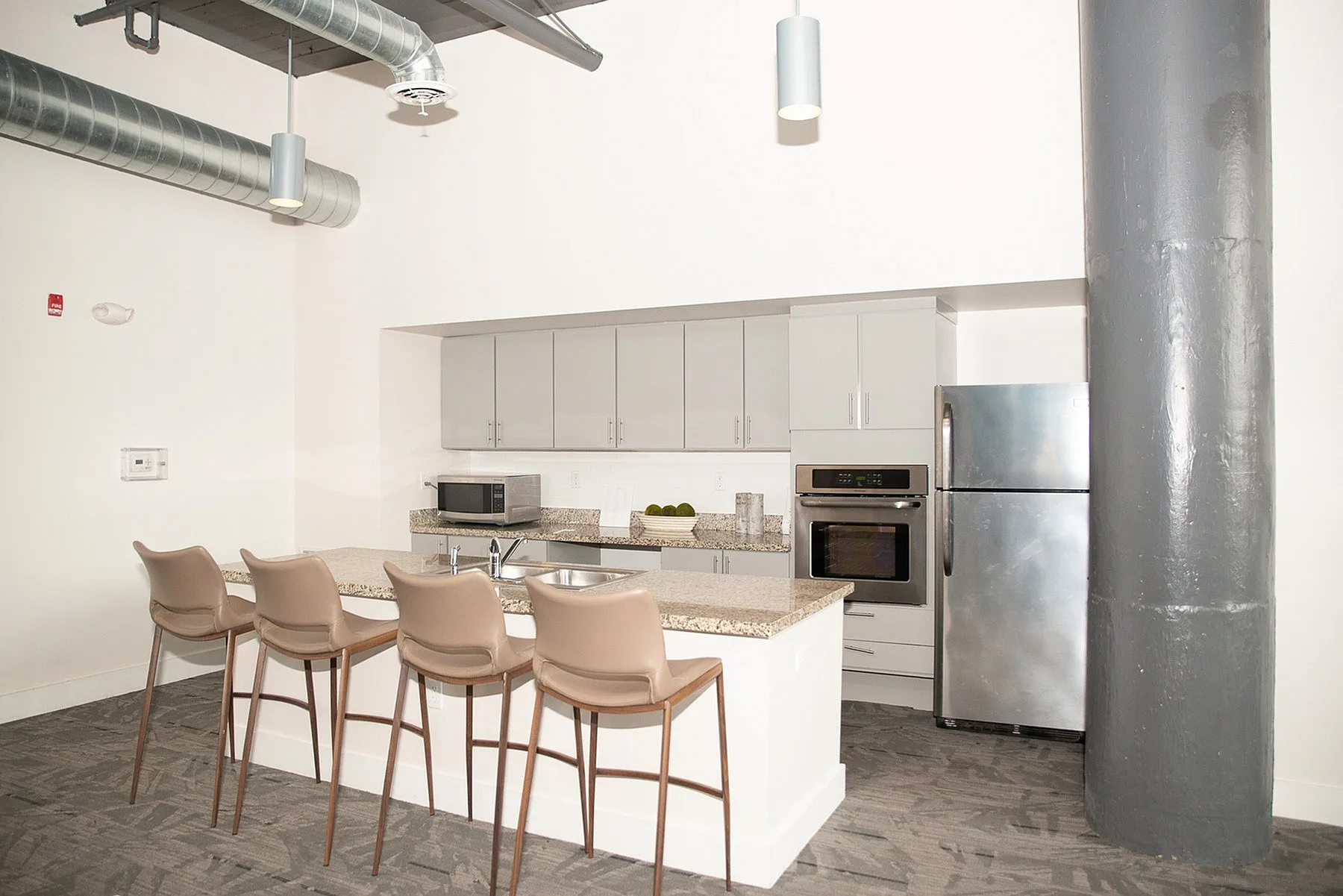 Modern kitchen with sleek granite countertops, stainless steel appliances, and chic bar seating for a stylish urban living experience.