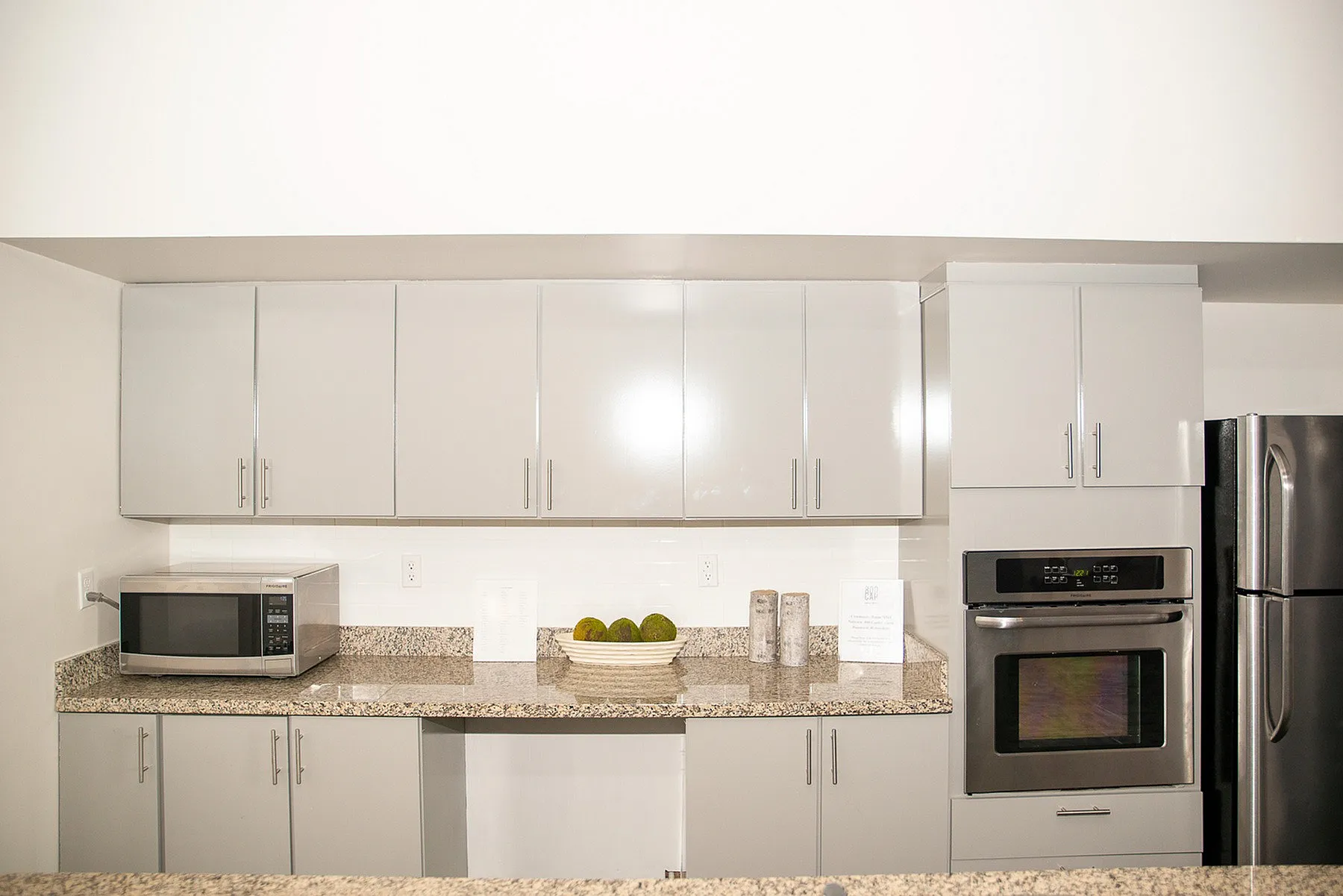 Modern kitchen with sleek gray cabinets, granite countertops, and stainless steel appliances, creating a contemporary and inviting culinary space.