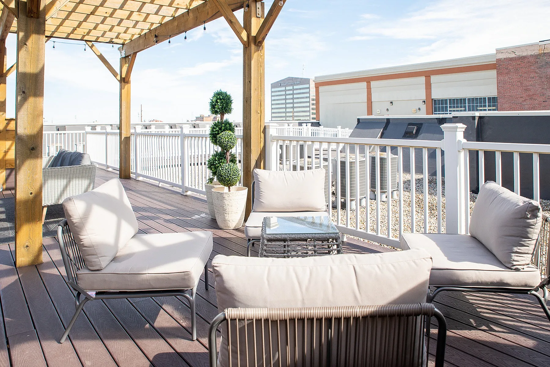 Charming rooftop terrace with comfortable seating and elegant pergola, offering urban views and a relaxing outdoor space.