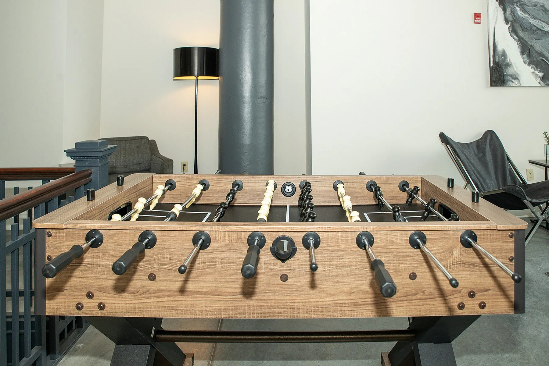 Chic recreation area featuring a sleek foosball table, modern decor, and cozy seating for leisure and enjoyment.