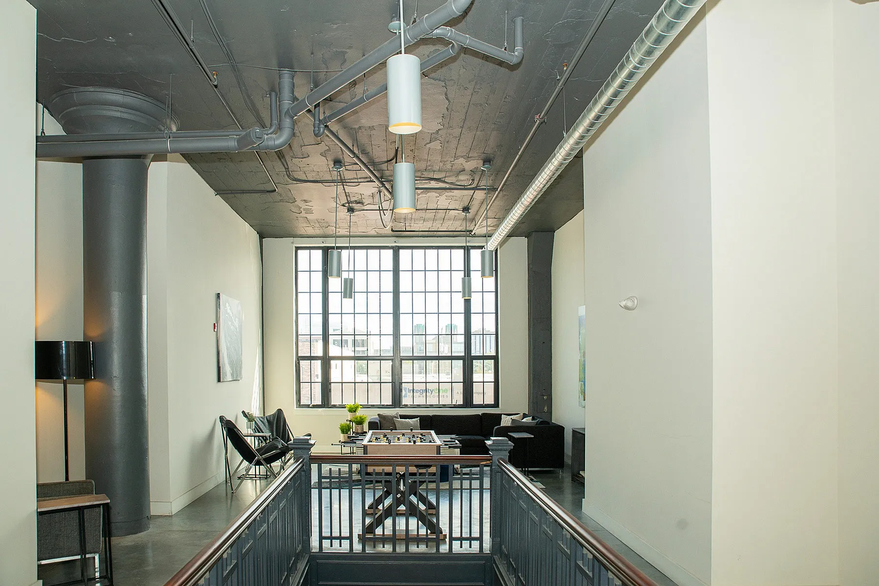Chic industrial loft with high ceilings, large windows, and stylish seating area for relaxation.