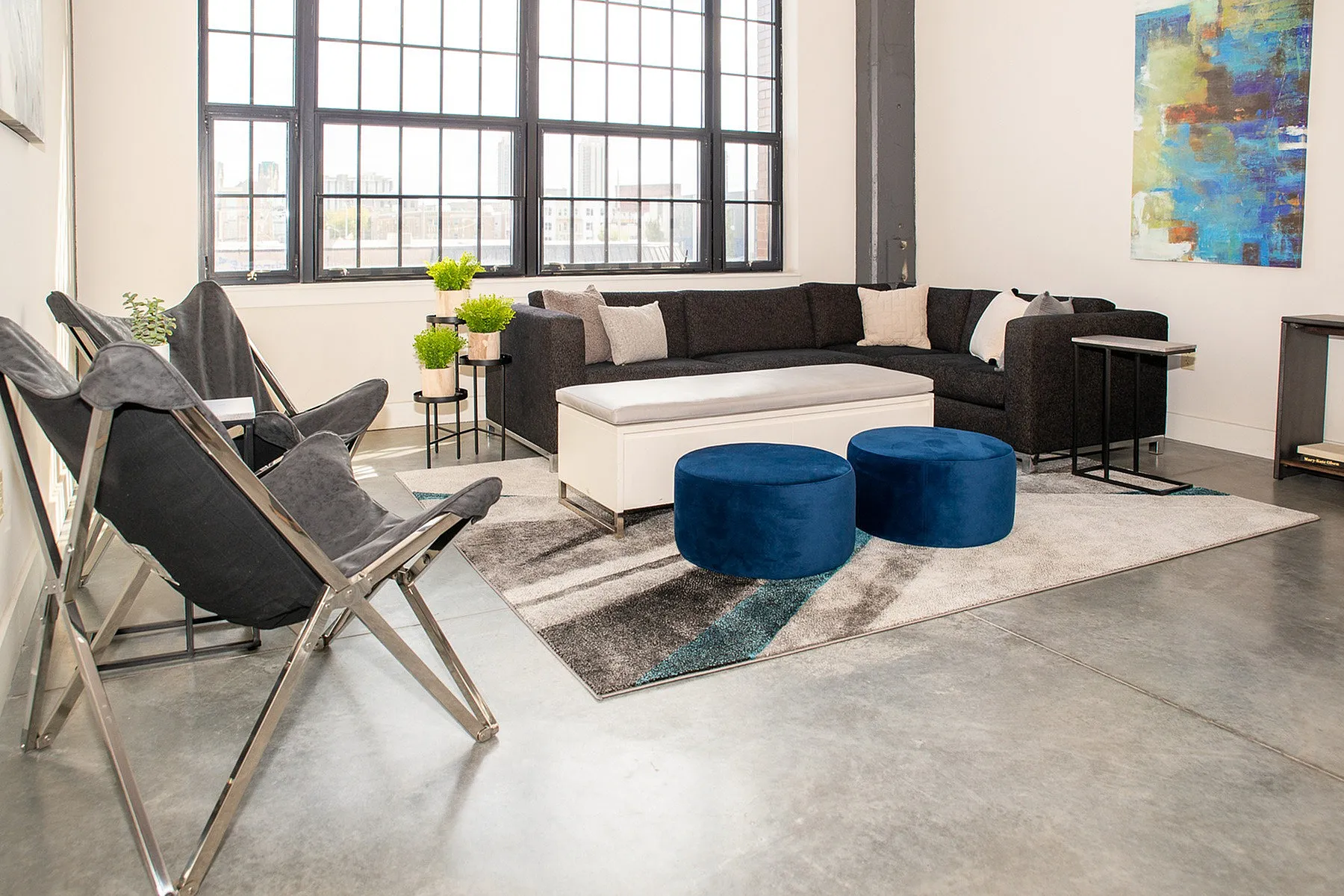 Chic city apartment living room with modern furniture, large windows, and vibrant artwork. Perfect blend of comfort and style for urban living.