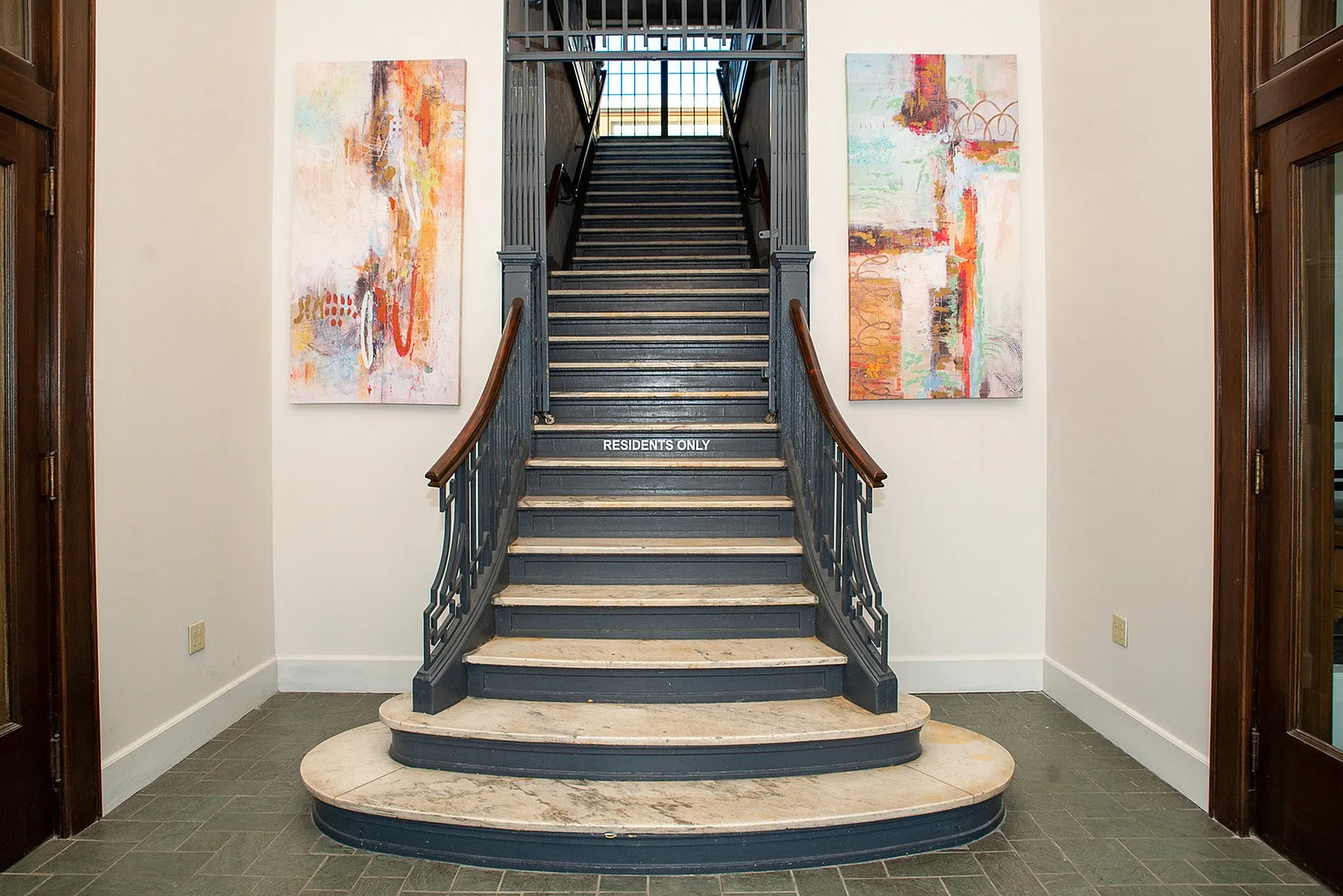 Elegant staircase with artistic decor and modern accents in a sophisticated apartment entrance.
