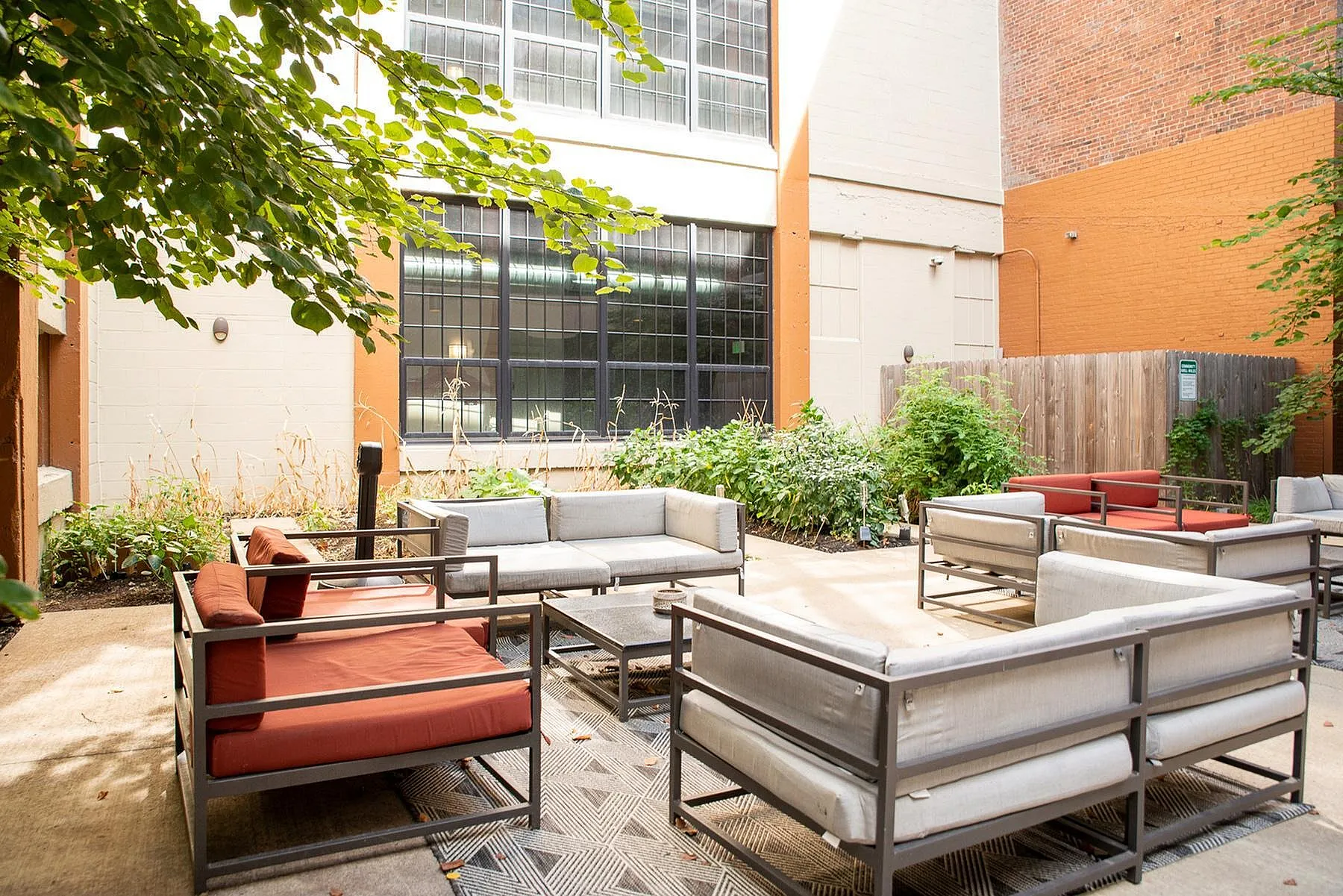 Charming outdoor patio with modern seating, lush greenery, and a serene atmosphere, perfect for relaxation.