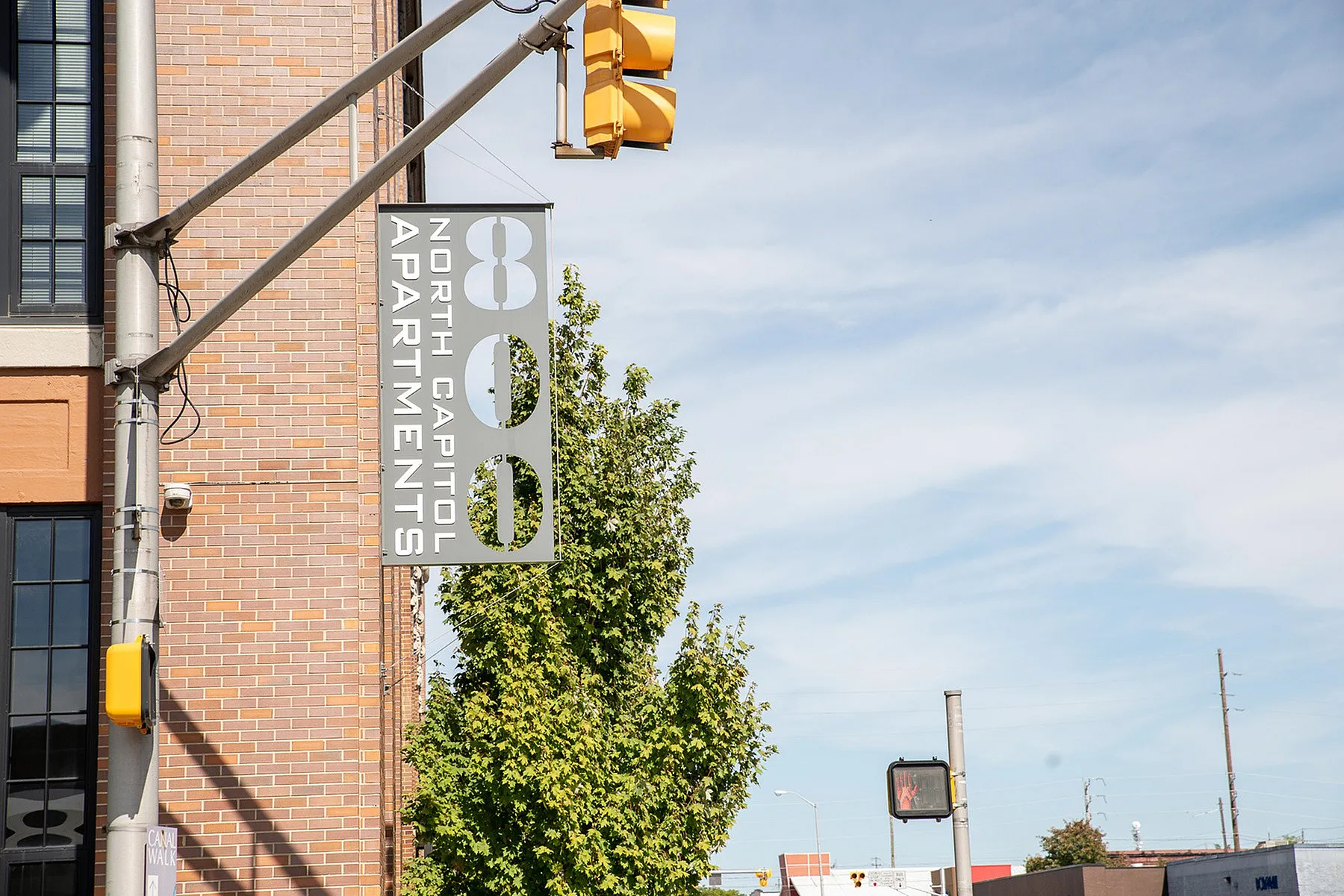 Modern and inviting brick exterior of 800 North Capitol Apartments, showcasing urban living with clear signage under a bright blue sky.