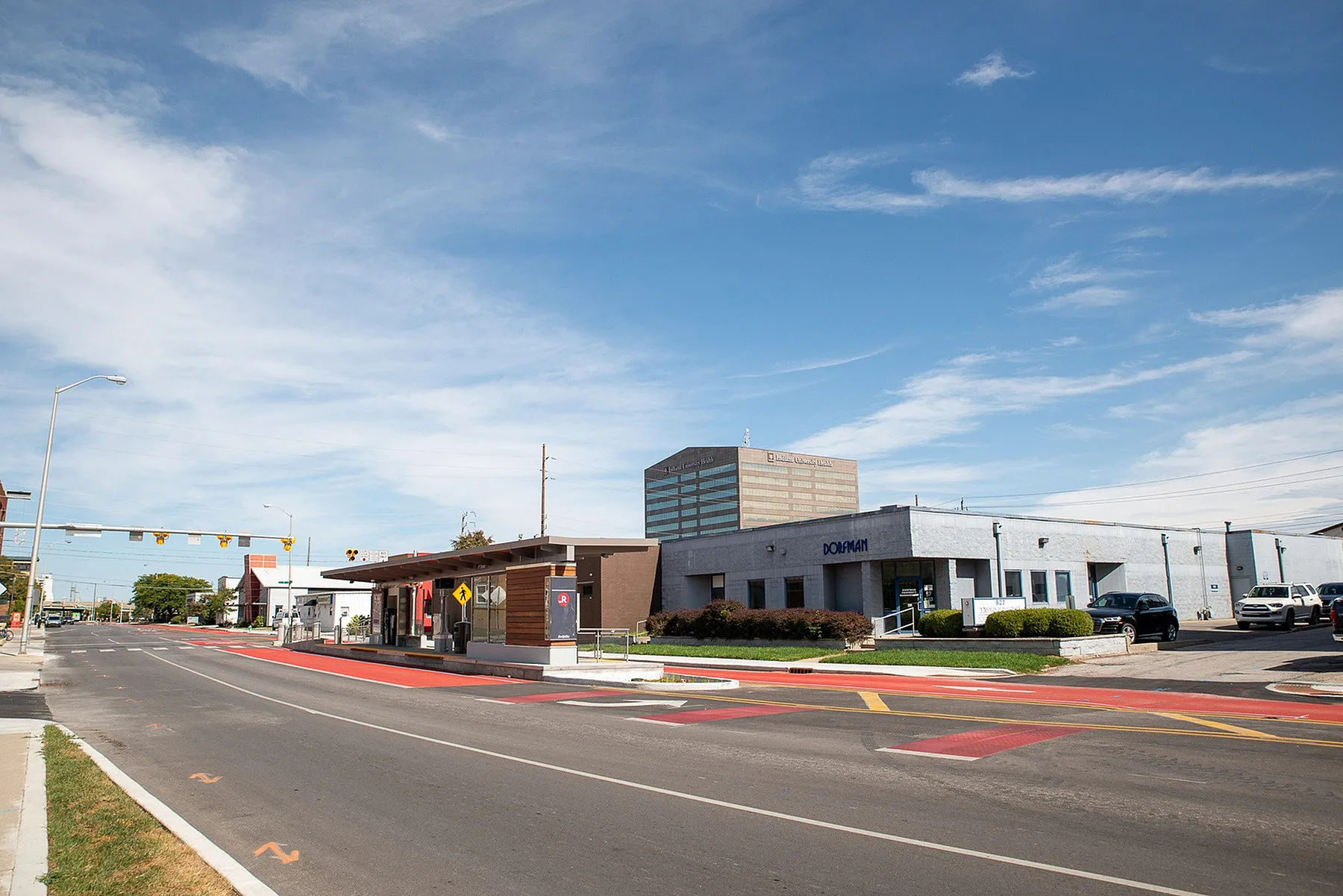 Charming urban view featuring modern office buildings and a sleek bus stop under a clear blue sky.