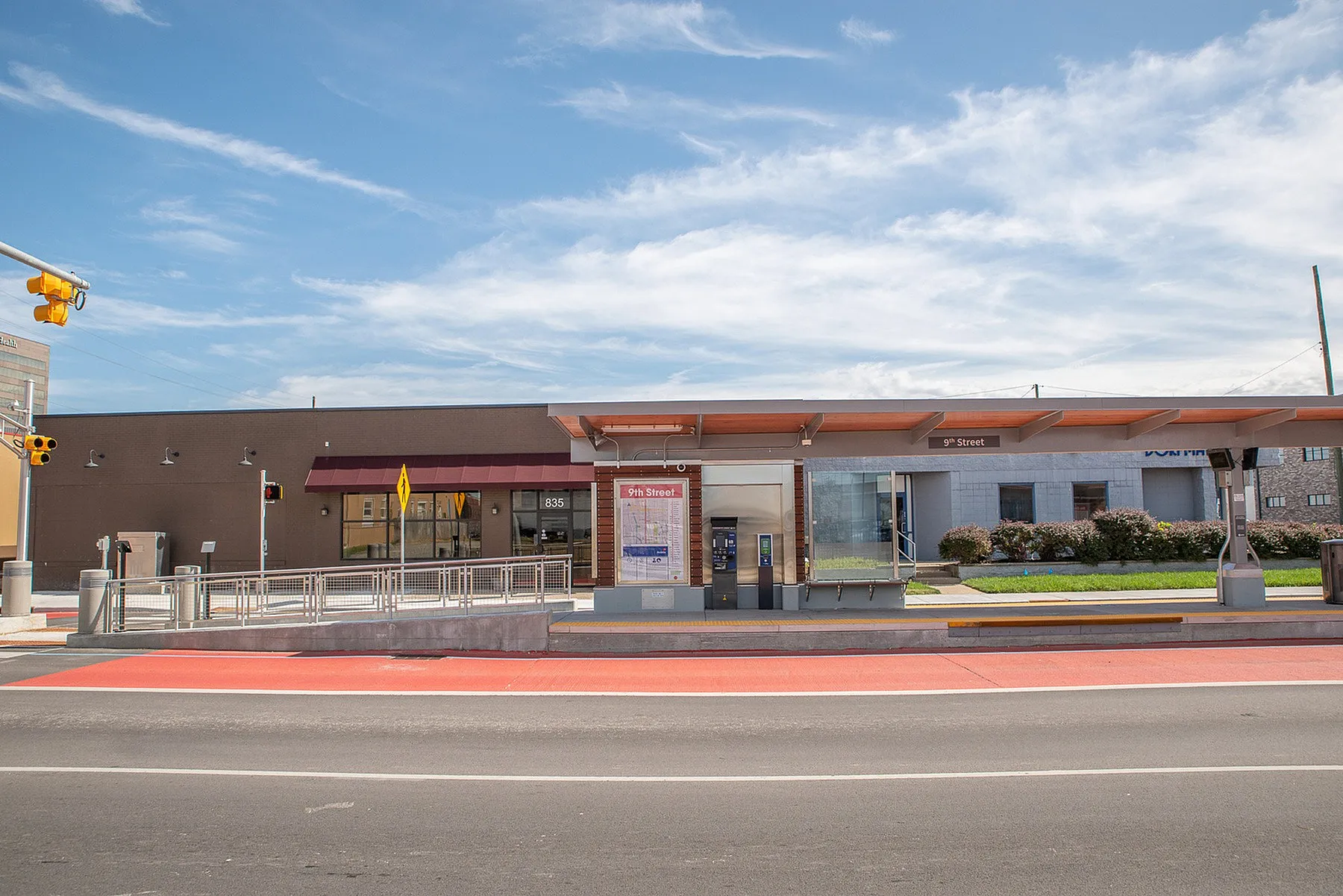 Modern urban bus stop at 9th Street with clear skies, featuring sleek architectural design and convenient amenities.