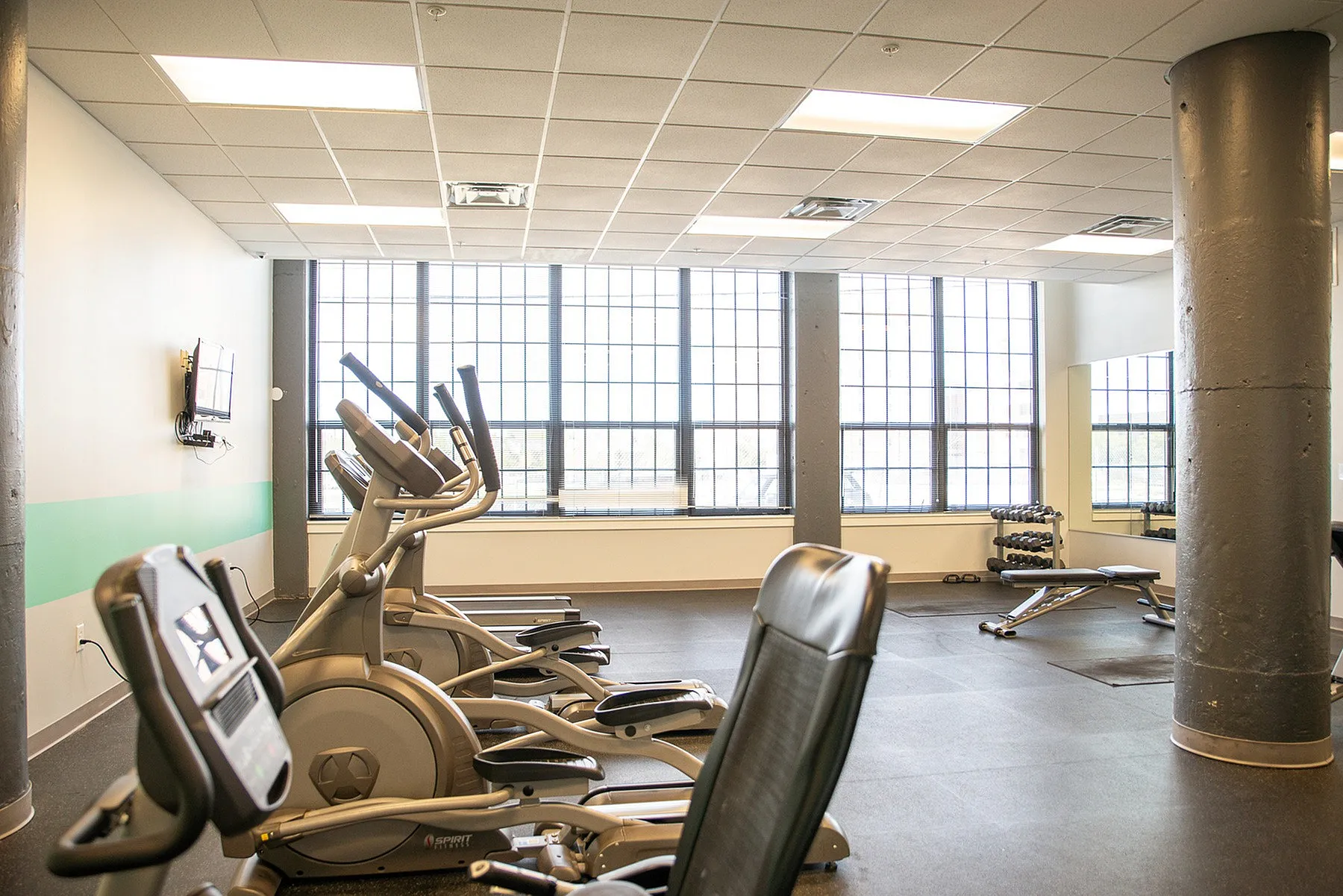 Modern fitness center with state-of-the-art exercise machines, expansive windows, and sleek design elements.
