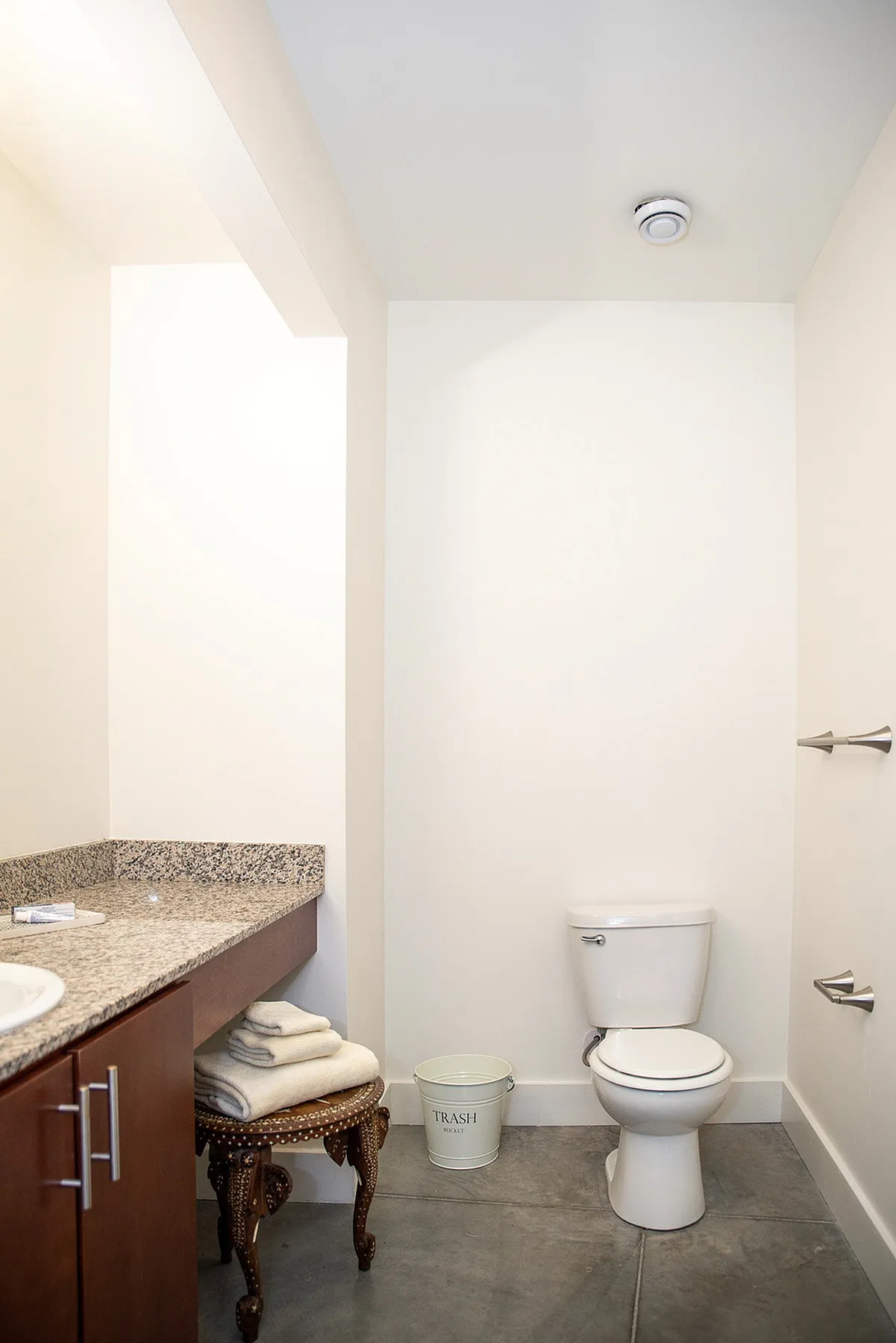 Modern bathroom with elegant granite countertop, sleek cabinetry, and pristine white walls for a fresh, clean look.