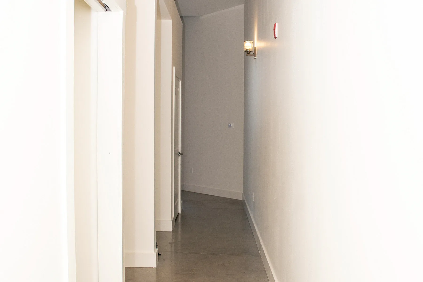 Bright and spacious hallway with modern lighting and sleek design, offering a welcoming atmosphere.