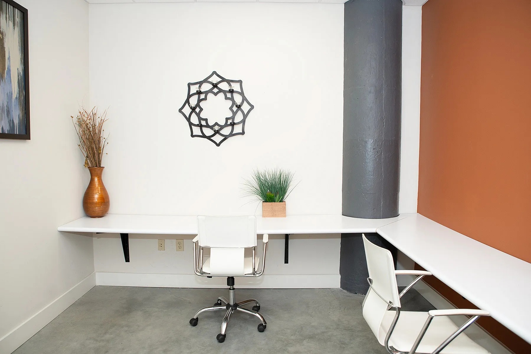 Modern home office with sleek white desks, stylish chairs, and artistic wall decor, perfect for productivity.