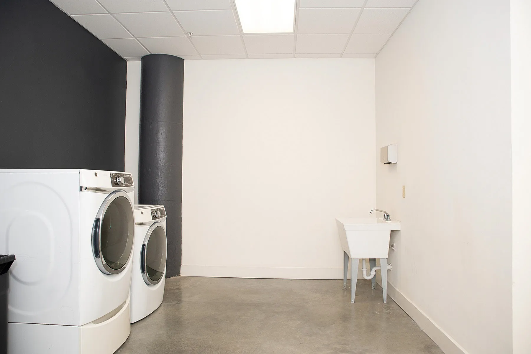 Modern laundry room with sleek washer and dryer, featuring a convenient utility sink, perfect for efficient and stylish home living.