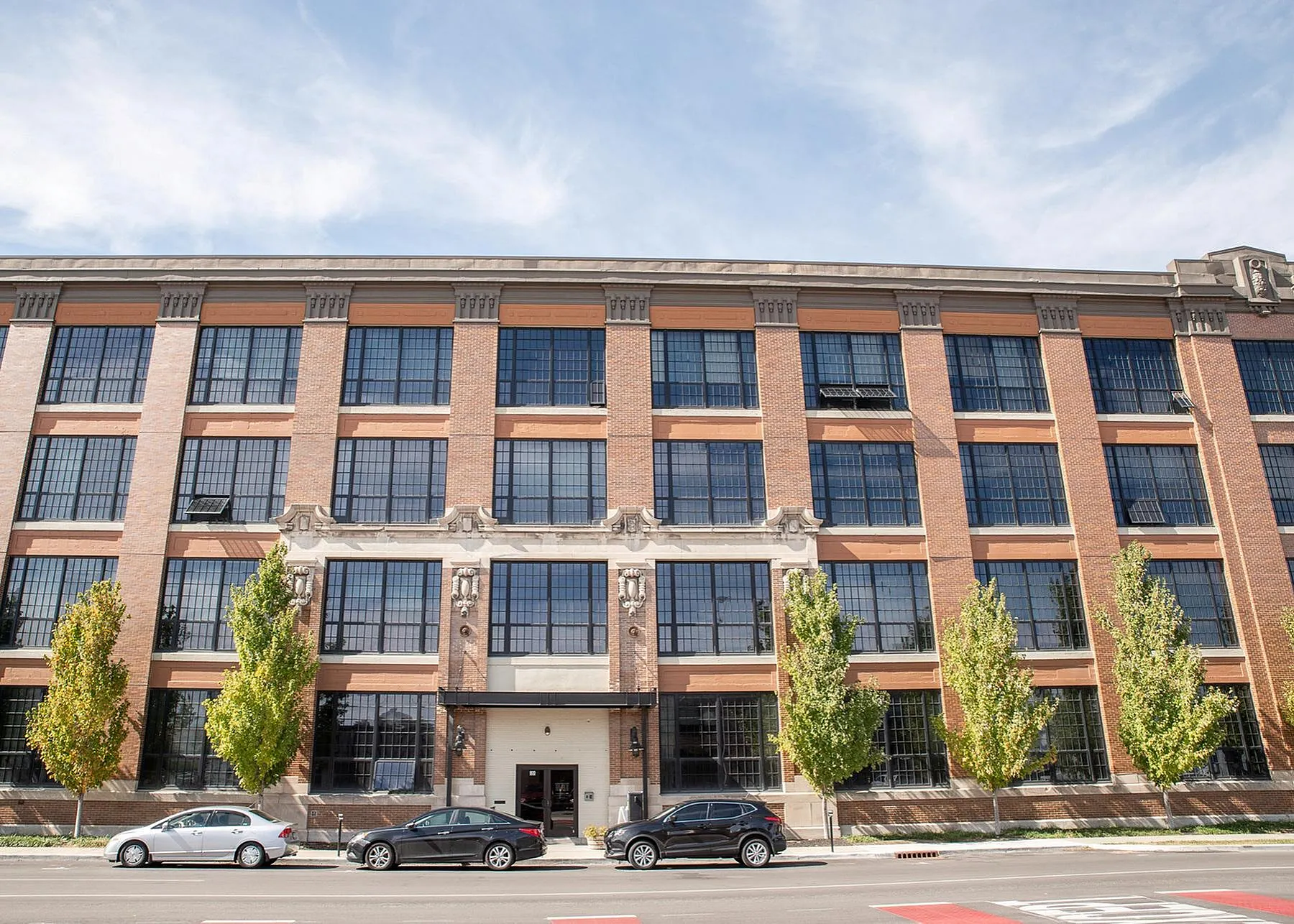 Charming brick building with large industrial-style windows, perfect for urban living.