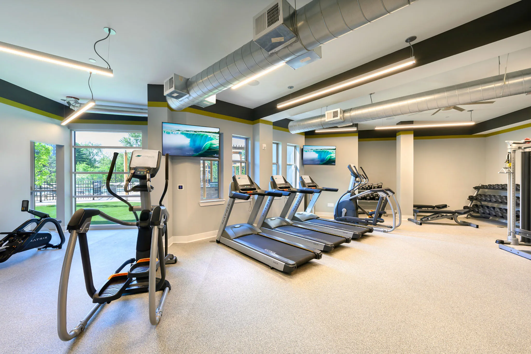 Modern fitness center with sleek treadmills, cutting-edge ellipticals, and a well-equipped weight area, perfect for energizing workouts.