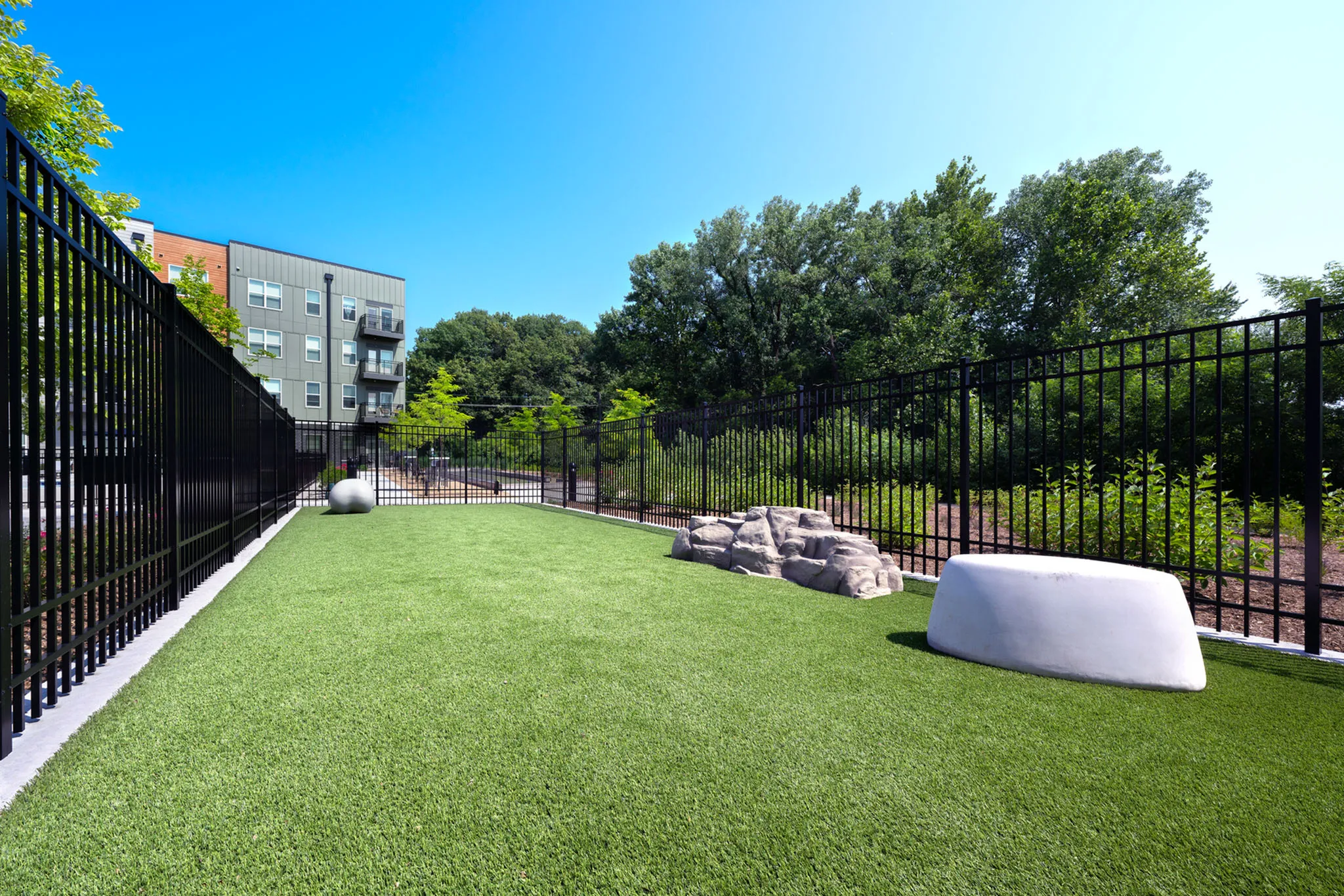 Serene outdoor space featuring lush green lawn, modern fencing, and natural landscape perfect for relaxation.