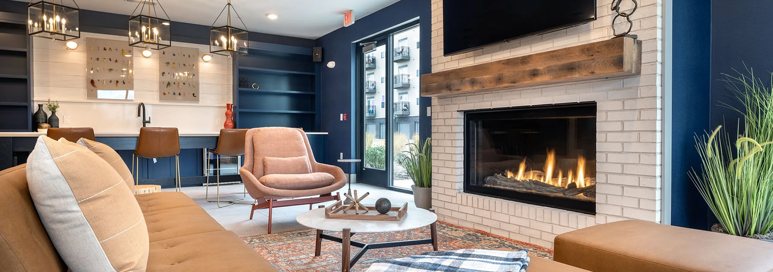 Luxurious living room showcasing a cozy fireplace, elegant furniture, and modern lighting fixtures, perfect for relaxation and entertaining.