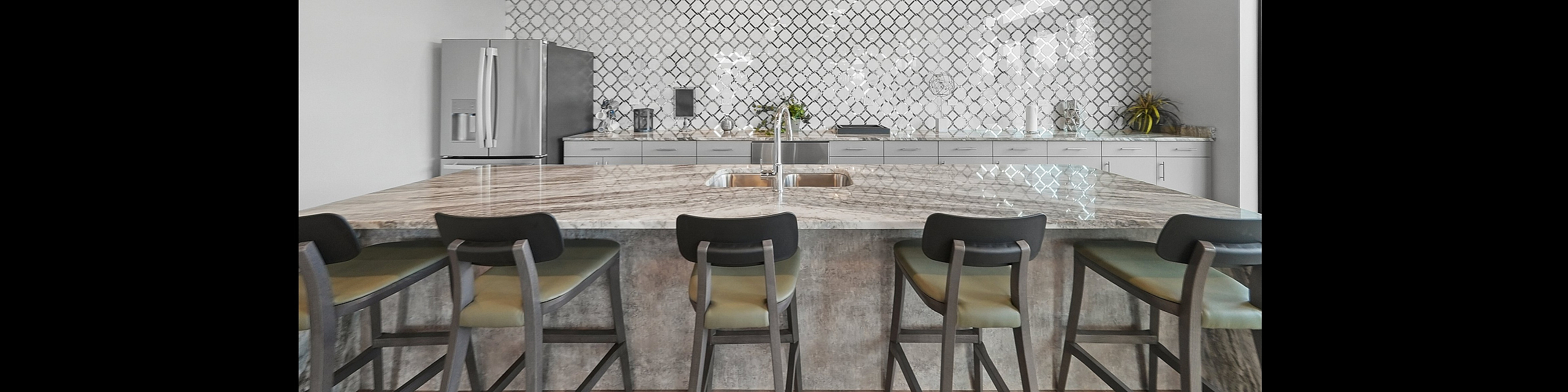 Modern kitchen showcasing a sleek marble island with comfortable seating, elegant pendant lighting, and a stylish patterned backsplash.