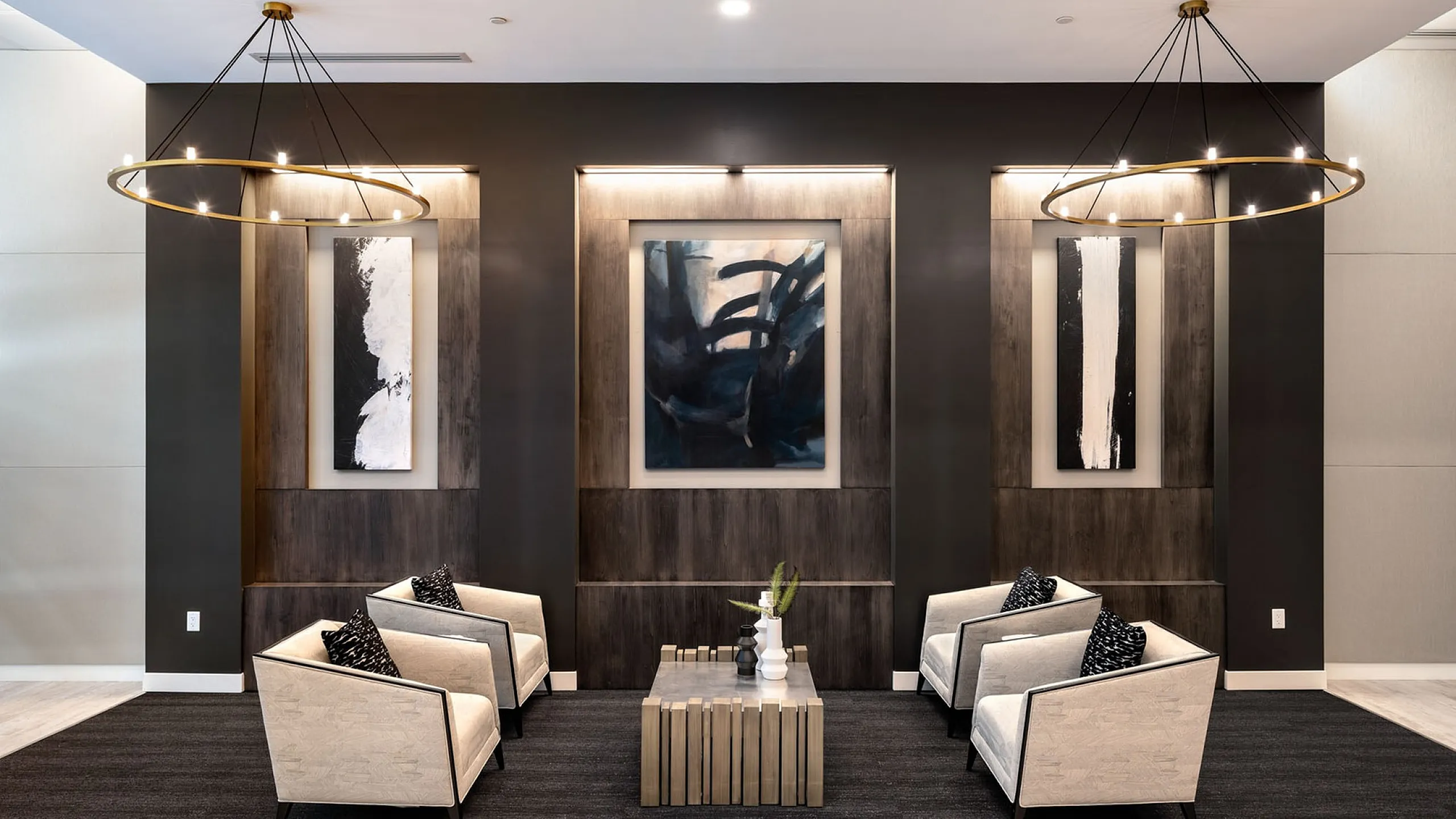Elegant modern lounge area featuring minimalist decor, contemporary art pieces, and sleek lighting fixtures.