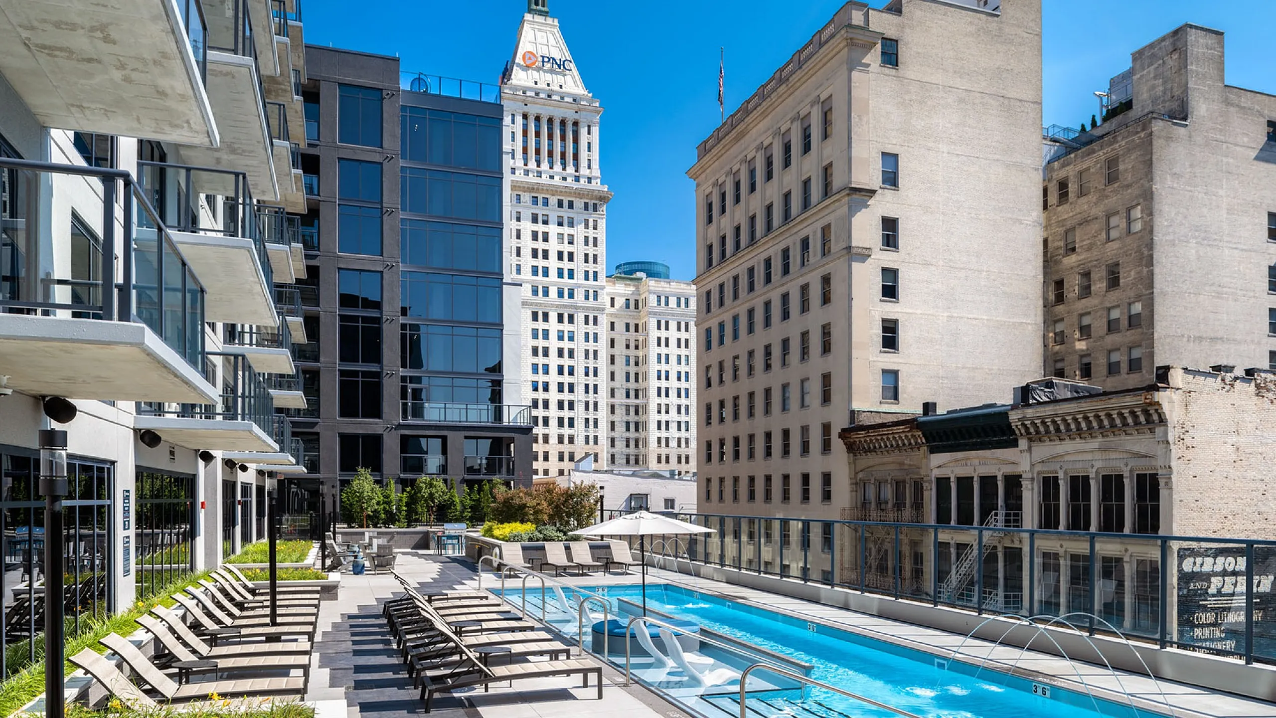 Luxurious rooftop pool with sun loungers and breathtaking city skyline views.