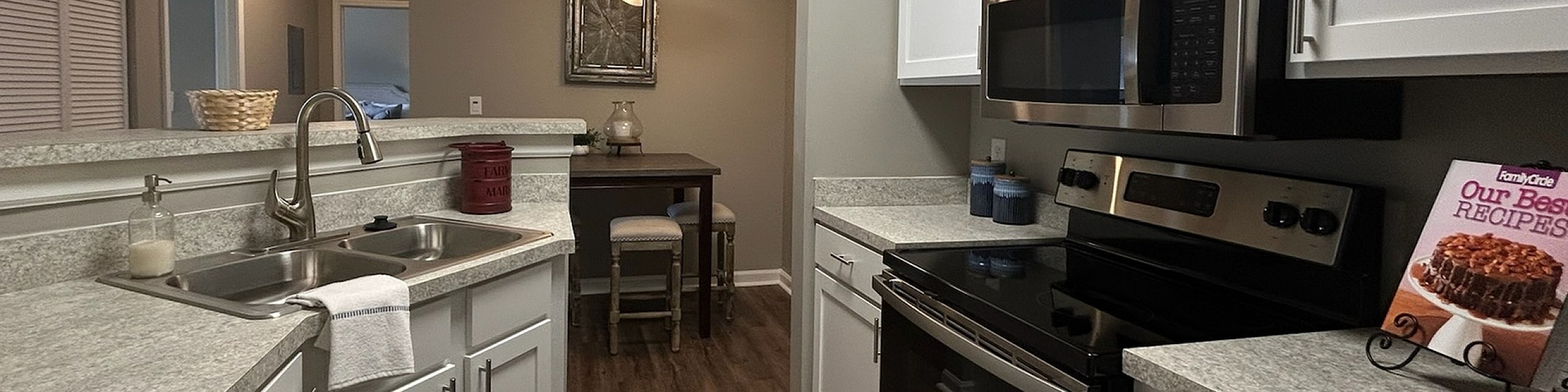Modern kitchen with sleek stainless steel appliances, elegant countertops, and warm wood flooring, creating a welcoming culinary space.