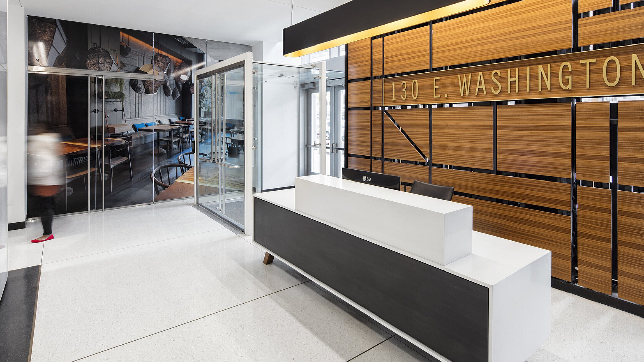 Modern lobby at 130 E. Washington with sleek reception desk and stylish wood paneling, offering a welcoming and contemporary atmosphere.