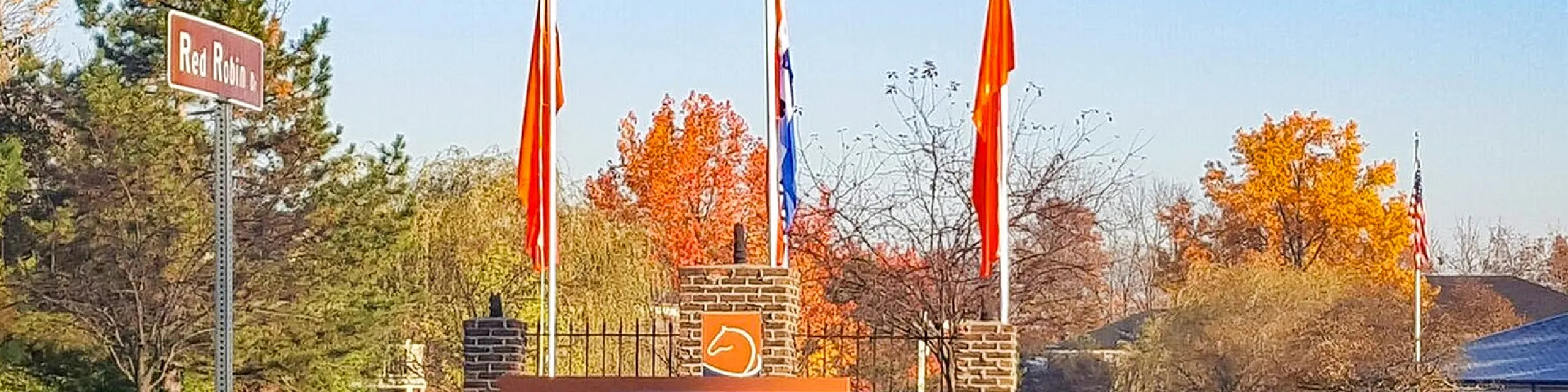 Inviting entrance to The Brixton Apartments with vibrant autumn foliage and welcoming signage.