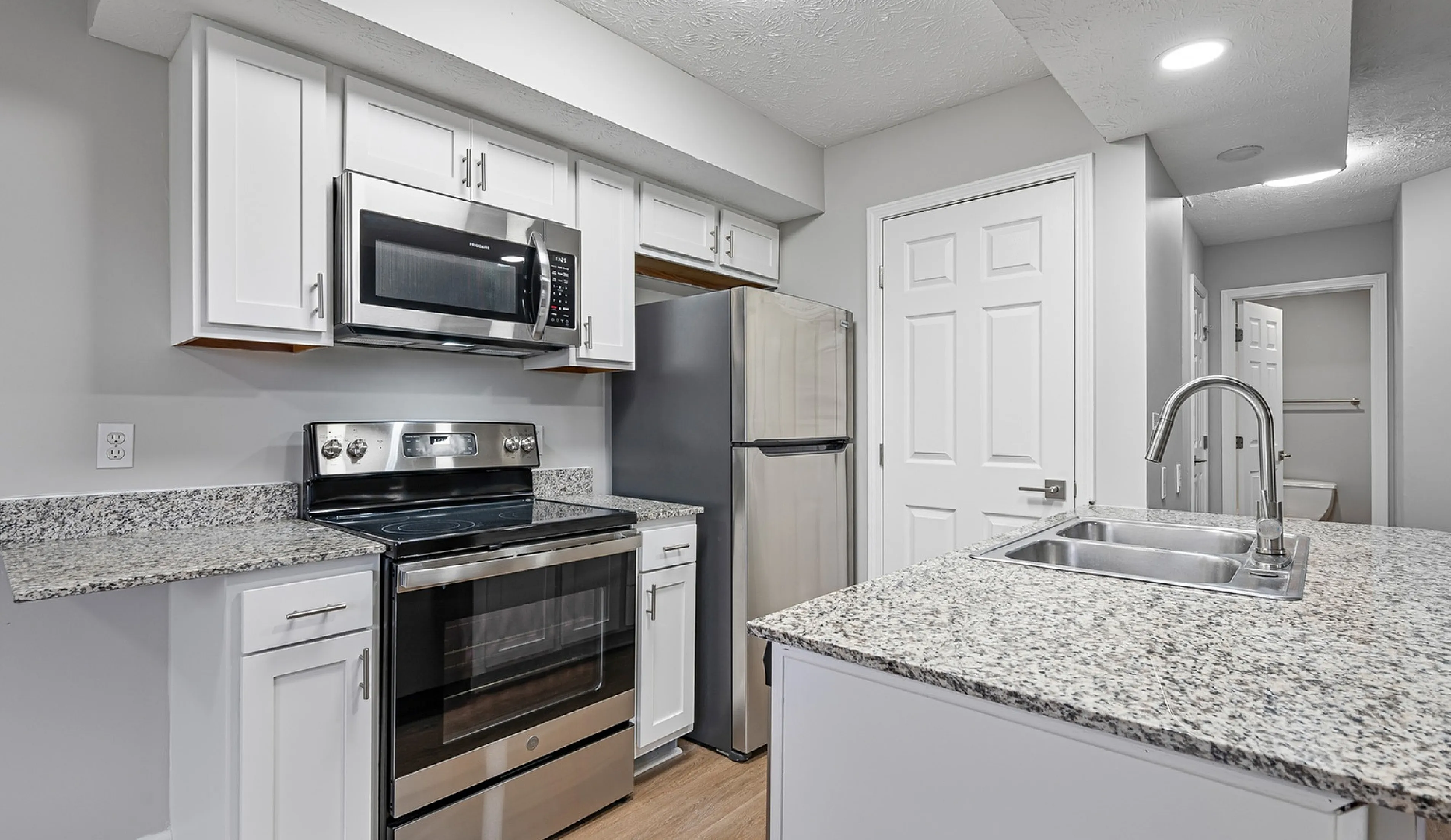 Modern kitchen with sleek stainless steel appliances, granite countertops, and a spacious design.
