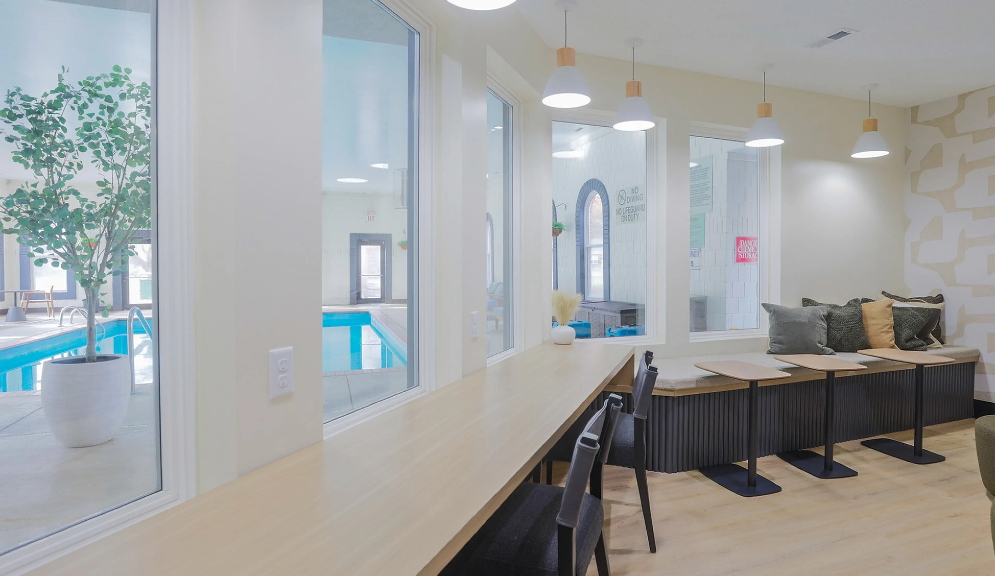 Bright and inviting interior with modern seating area, large windows, and a view of the indoor pool, perfect for relaxation and entertainment.