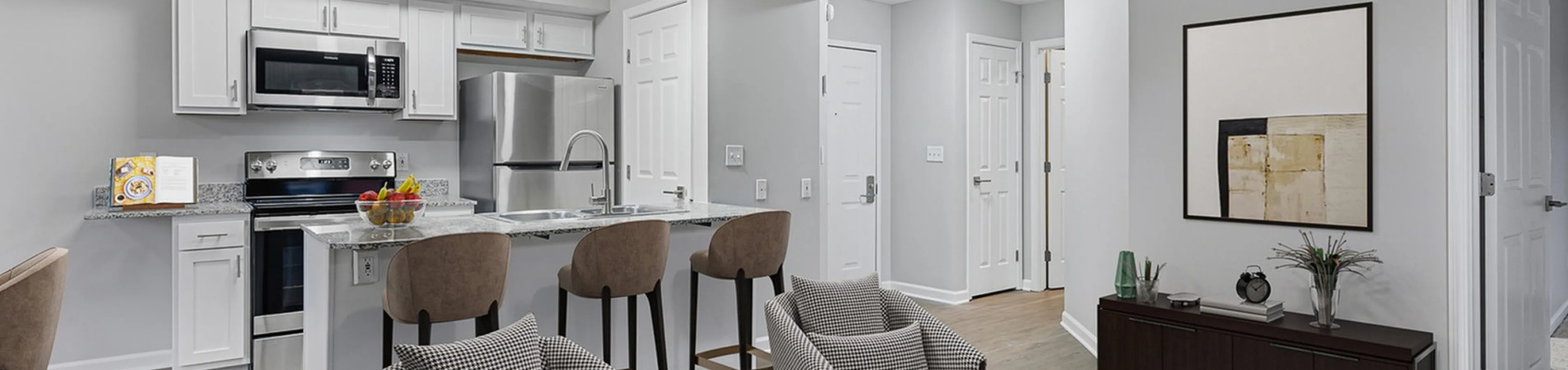 Modern open-concept living space with stylish kitchen, elegant seating, and contemporary decor in a luxurious apartment.