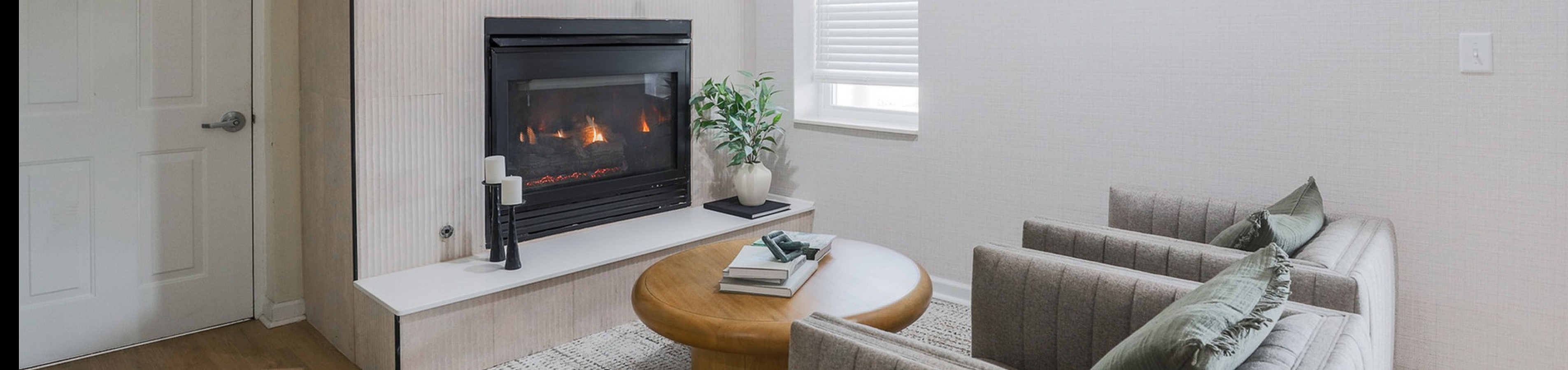Cozy living room featuring a modern fireplace, elegant shelving with decor, and comfortable seating, perfect for relaxation.