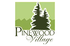 Elegant Pinewood Village logo featuring stylized pine trees against a serene green mountain backdrop, conveying a sense of tranquility and natural beauty.
