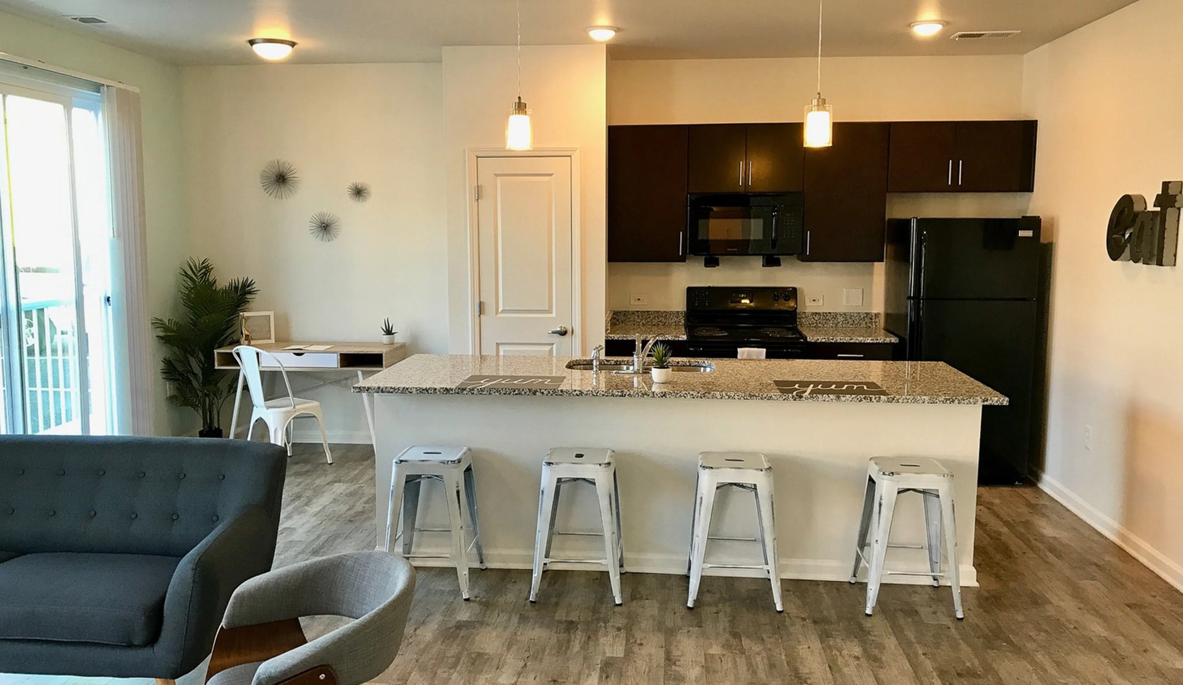 Modern open-concept apartment with sleek kitchen, inviting living area, and stylish breakfast bar seating.