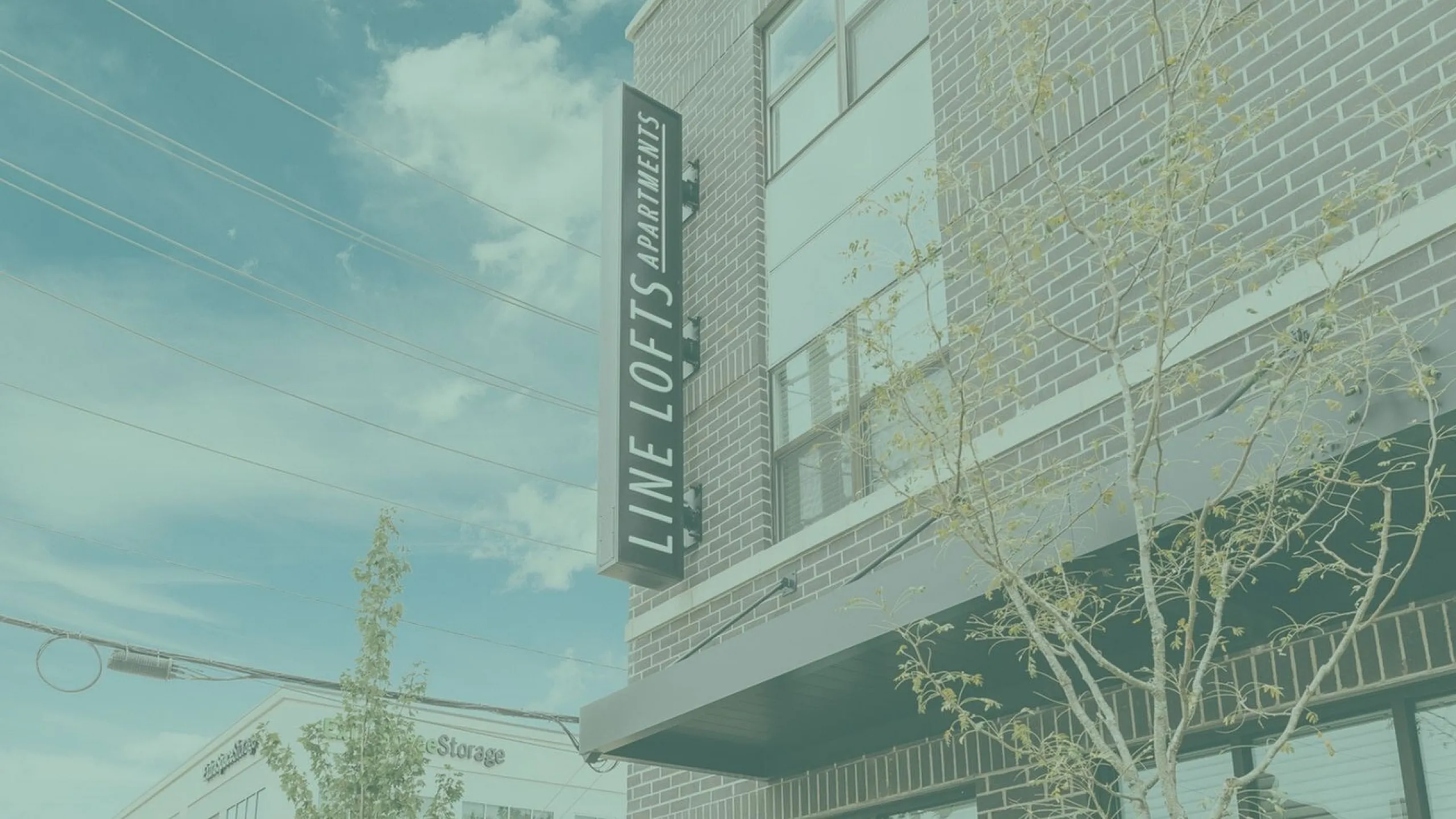 Chic urban Line Lofts Apartments exterior with modern brick architecture against a bright blue sky.
