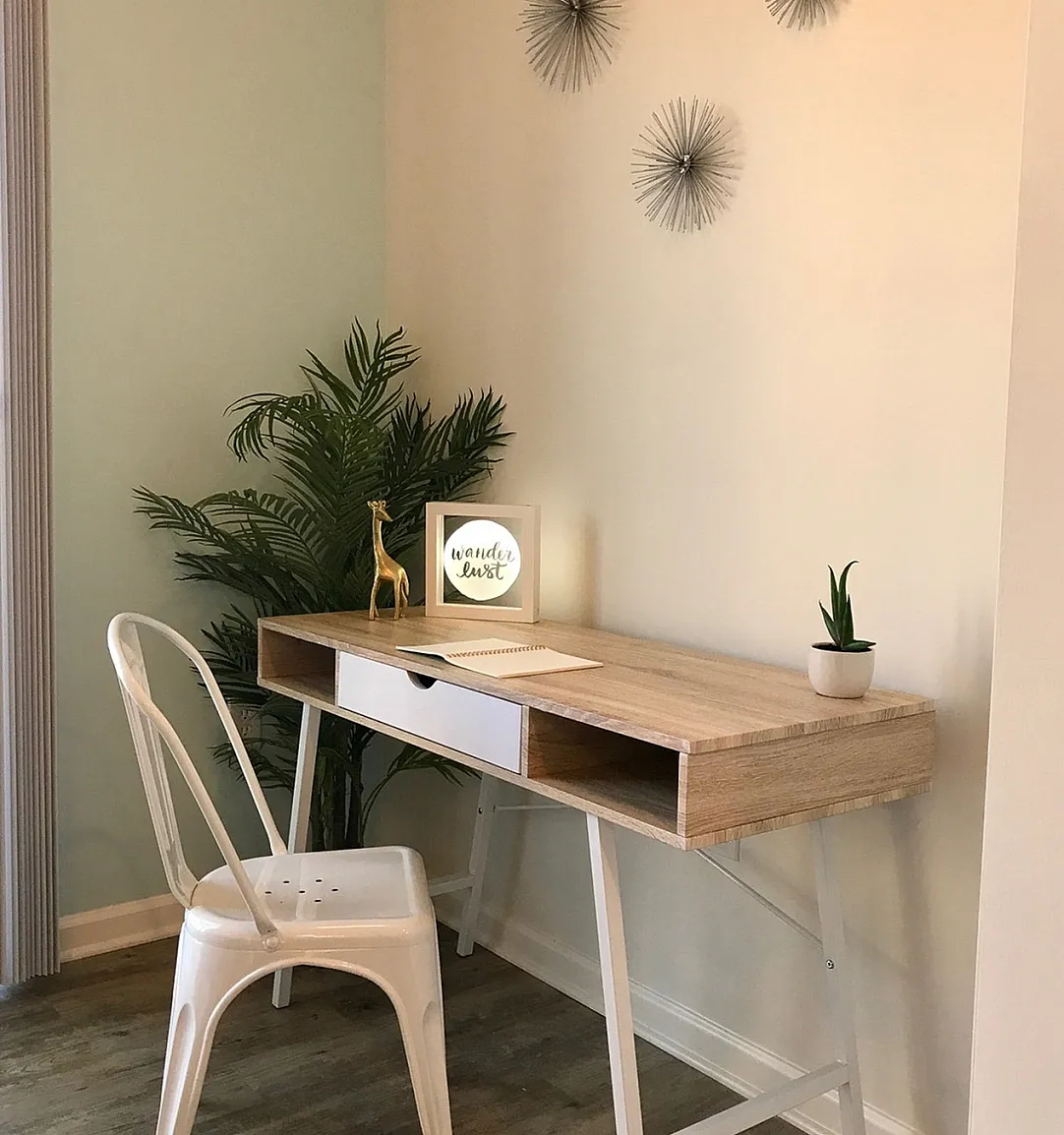 Chic home office space with a minimalist wooden desk, modern white chair, and stylish decor accents for a productive and inspiring environment.