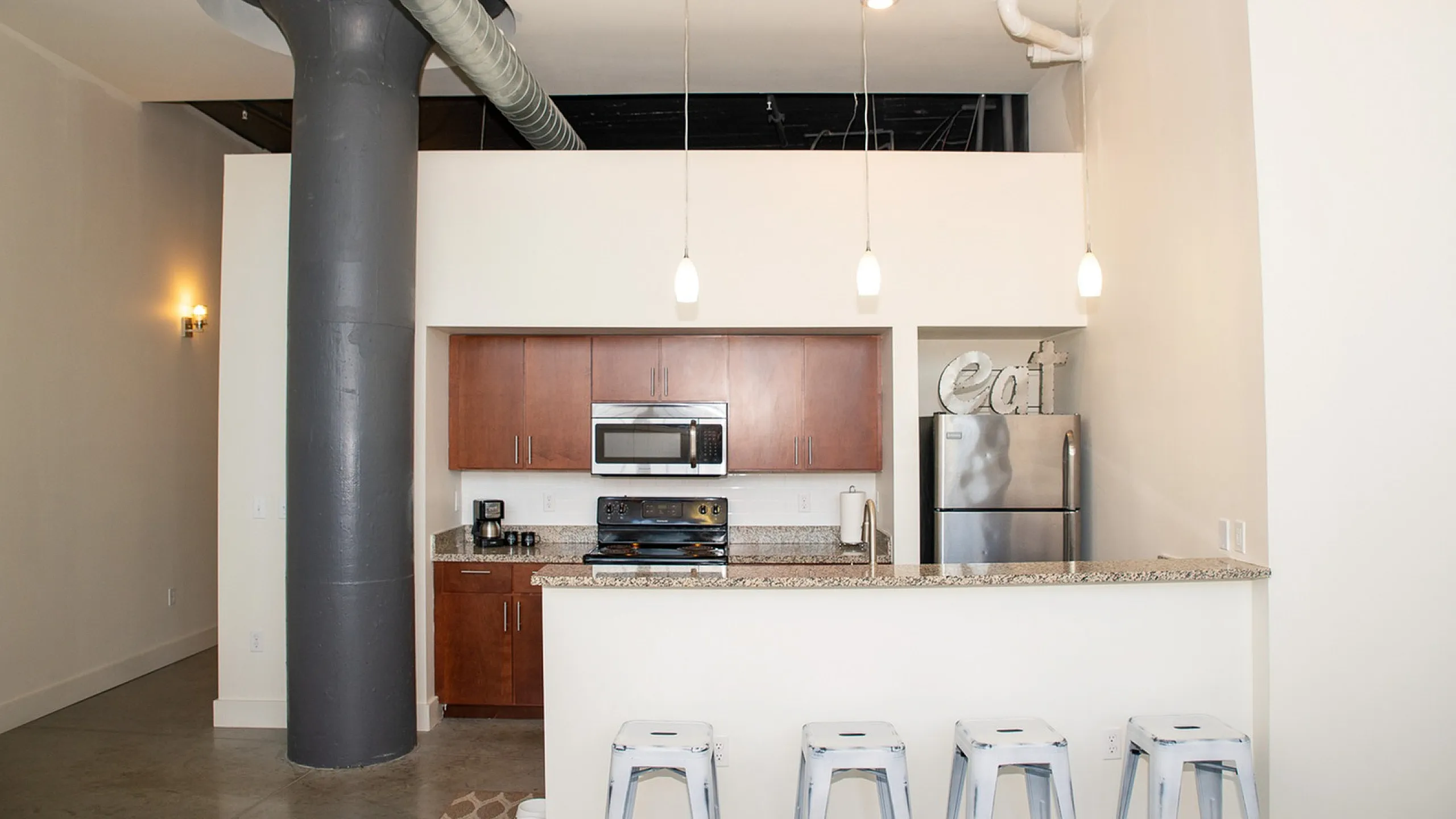 Sleek modern kitchen with stainless steel appliances, granite countertops, and stylish pendant lighting.