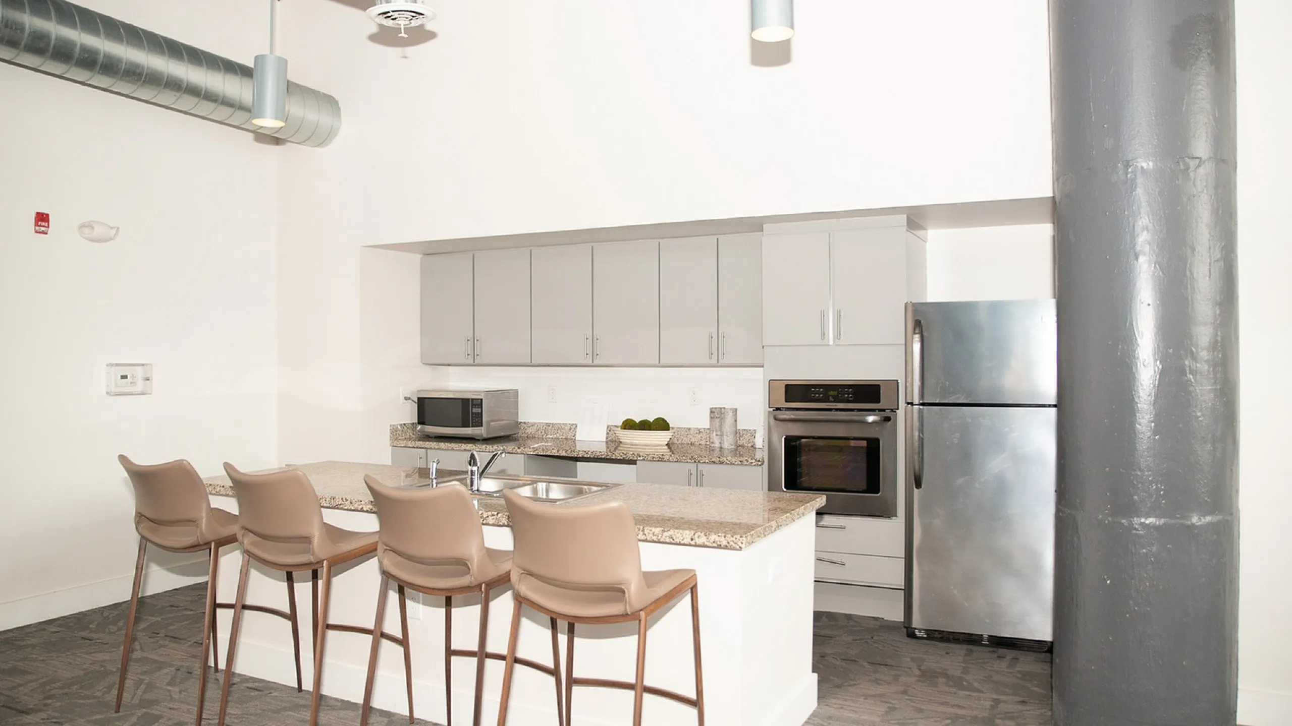 Contemporary kitchen featuring sleek cabinetry, stainless steel appliances, and a chic breakfast bar with stylish seating.