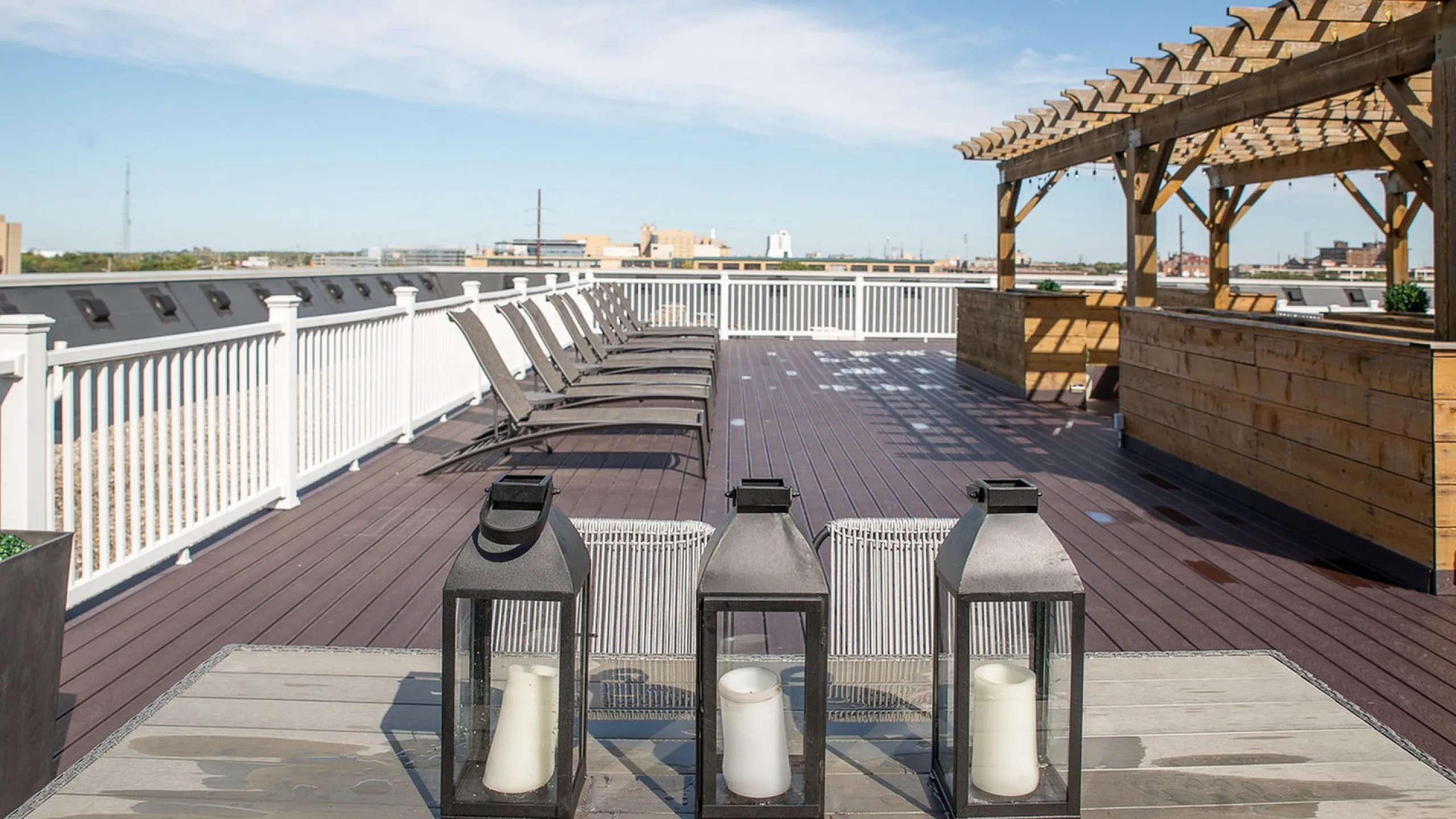 Chic rooftop terrace with stylish pergola, modern seating, and city views, perfect for relaxing under sunny skies.