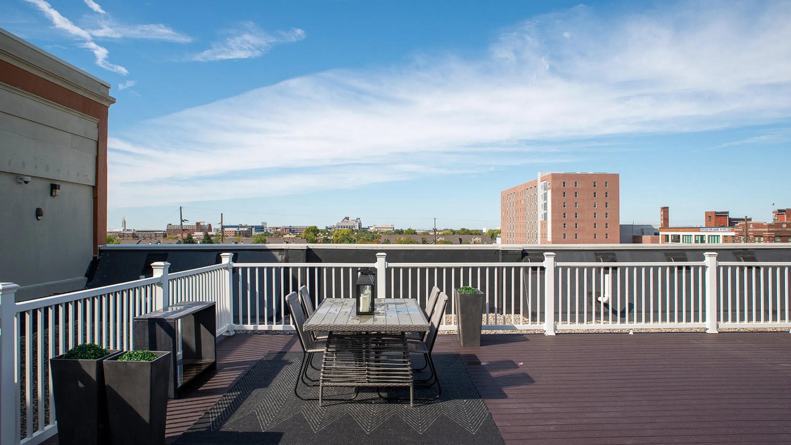 Chic rooftop terrace with stylish outdoor dining set and stunning cityscape views, perfect for urban living enthusiasts.