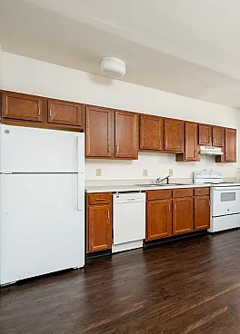 Bright and inviting kitchen with modern appliances and rich wooden cabinetry, featuring ample natural light and spacious hardwood floors.