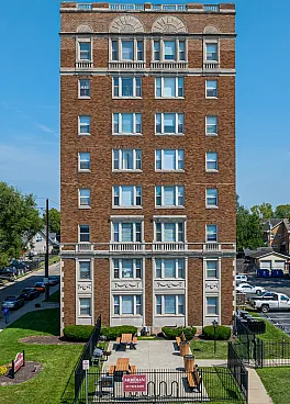 Charming brick apartment building with a classic facade and well-maintained front garden, set in a vibrant neighborhood.