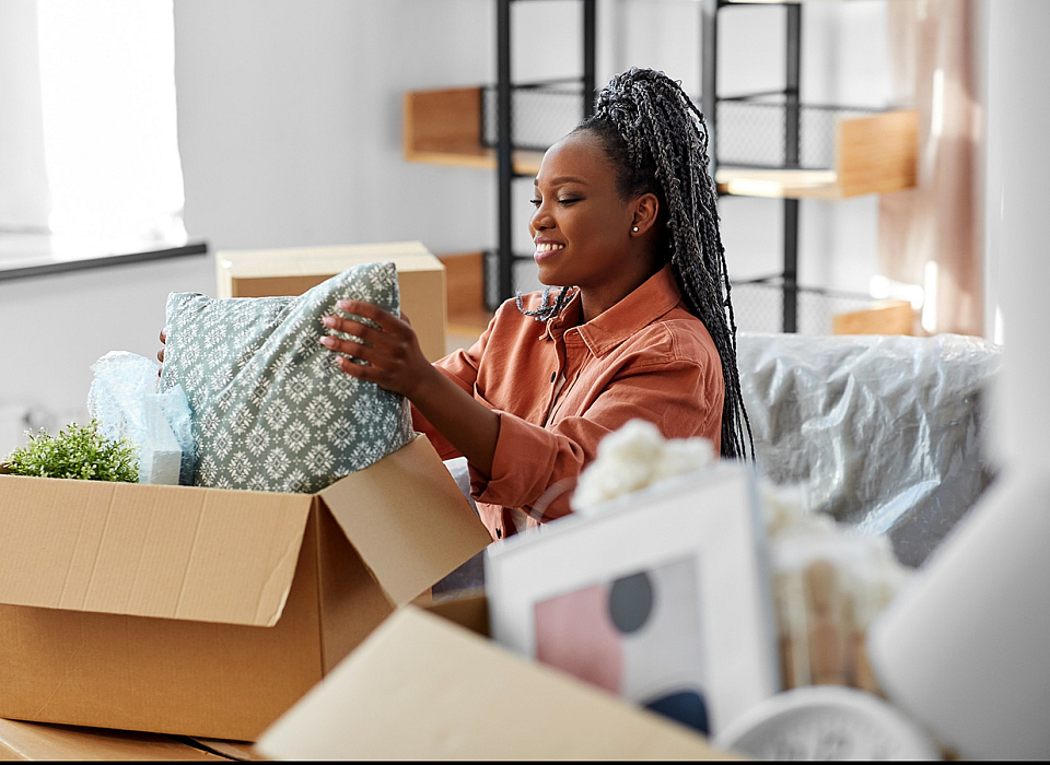 Joyful moment of unpacking in a cozy, light-filled apartment, featuring stylish decor and lively greenery.