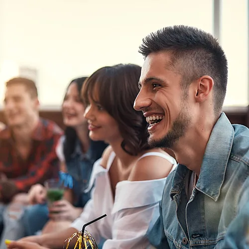 Group of friends enjoying a cozy, sunlit living space exuding warmth and camaraderie.