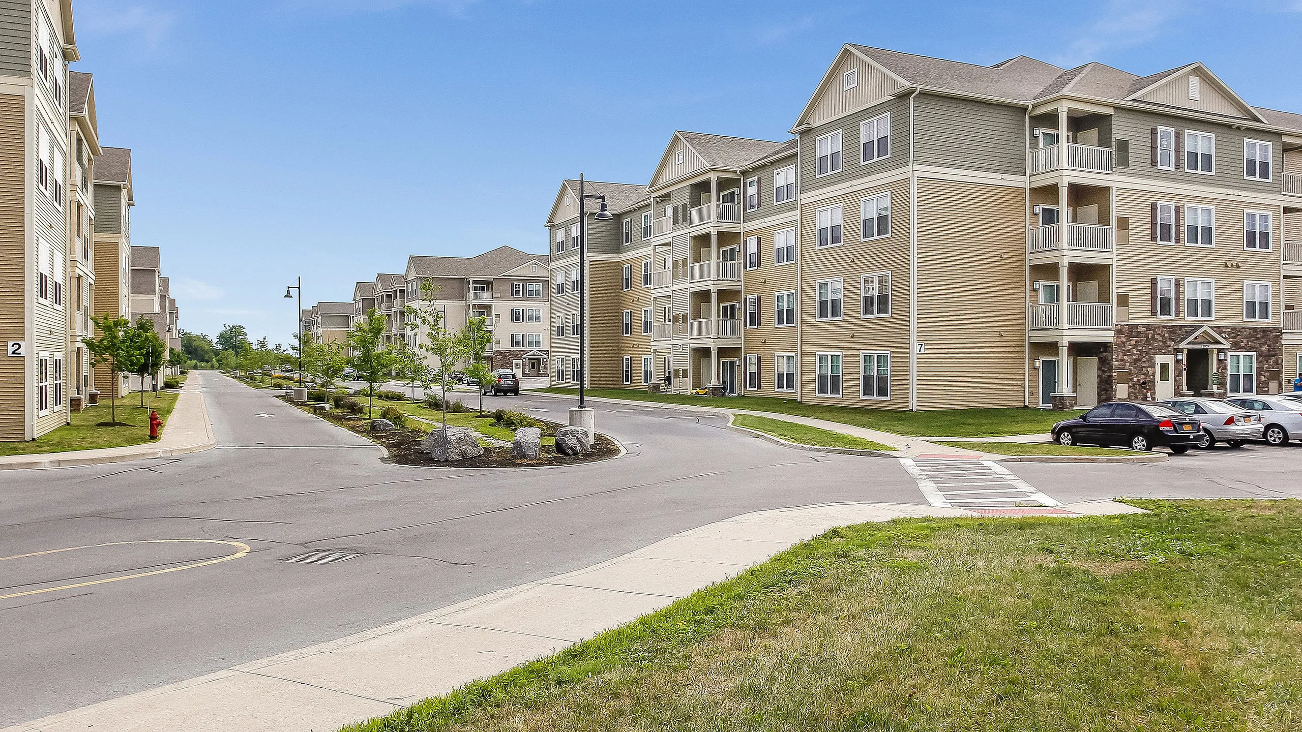 Charming apartment complex with modern architecture, surrounded by lush greenery and a well-maintained driveway. Ideal for comfortable living in a serene neighborhood.