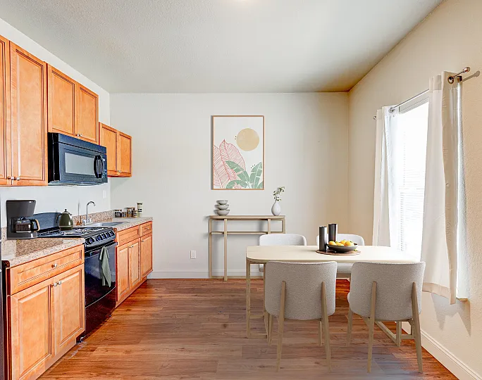 Inviting kitchen with modern appliances, sleek wooden cabinets, and a cozy dining nook with natural light.