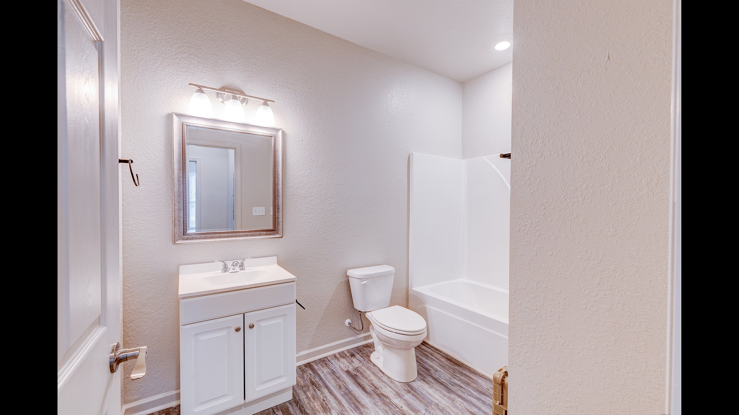 Contemporary bathroom featuring elegant lighting, sleek vanity, and a pristine bathtub for a modern living experience.