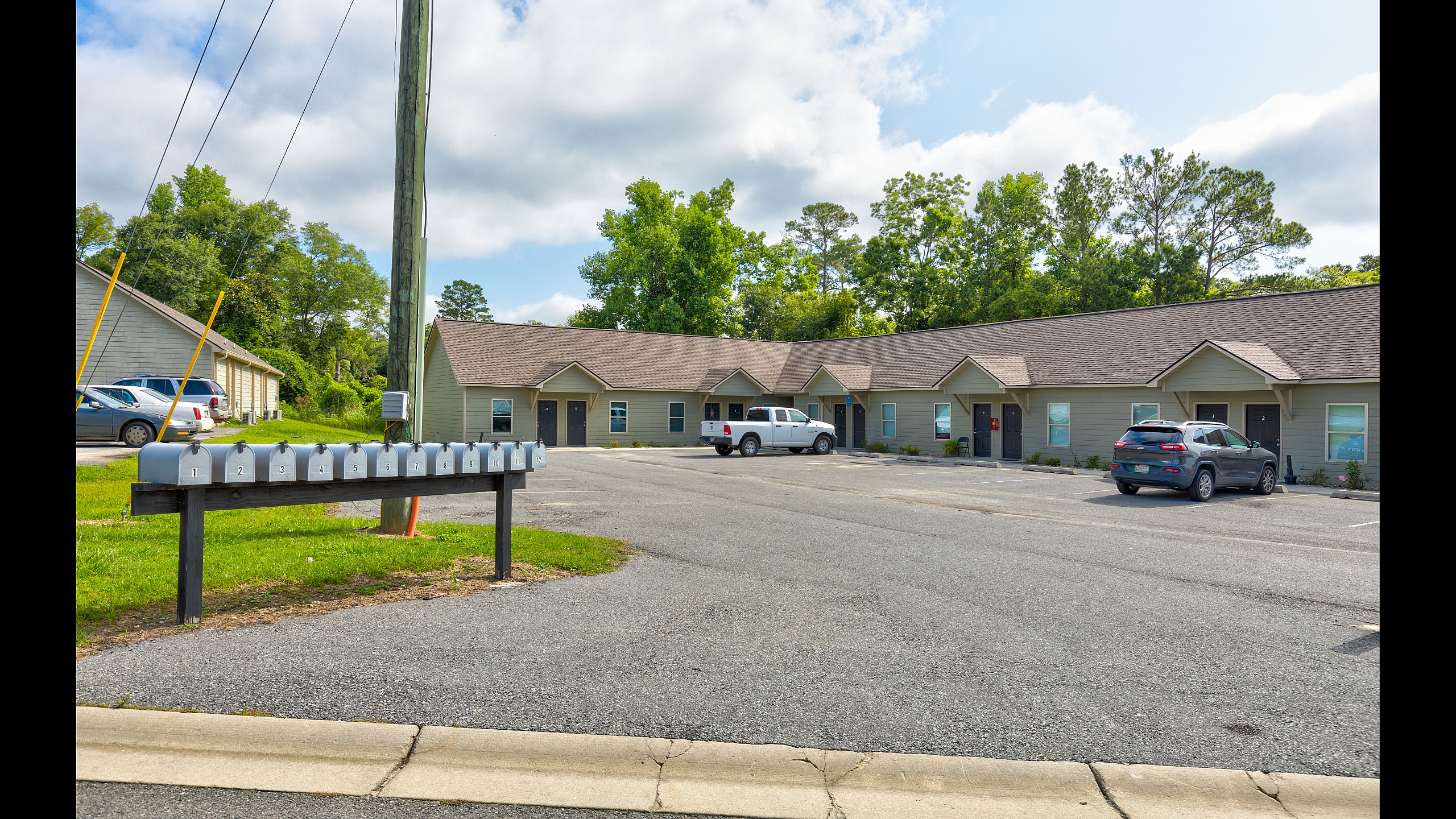 Inviting and spacious apartment complex with modern design, ample parking, and scenic greenery, perfect for comfortable living.