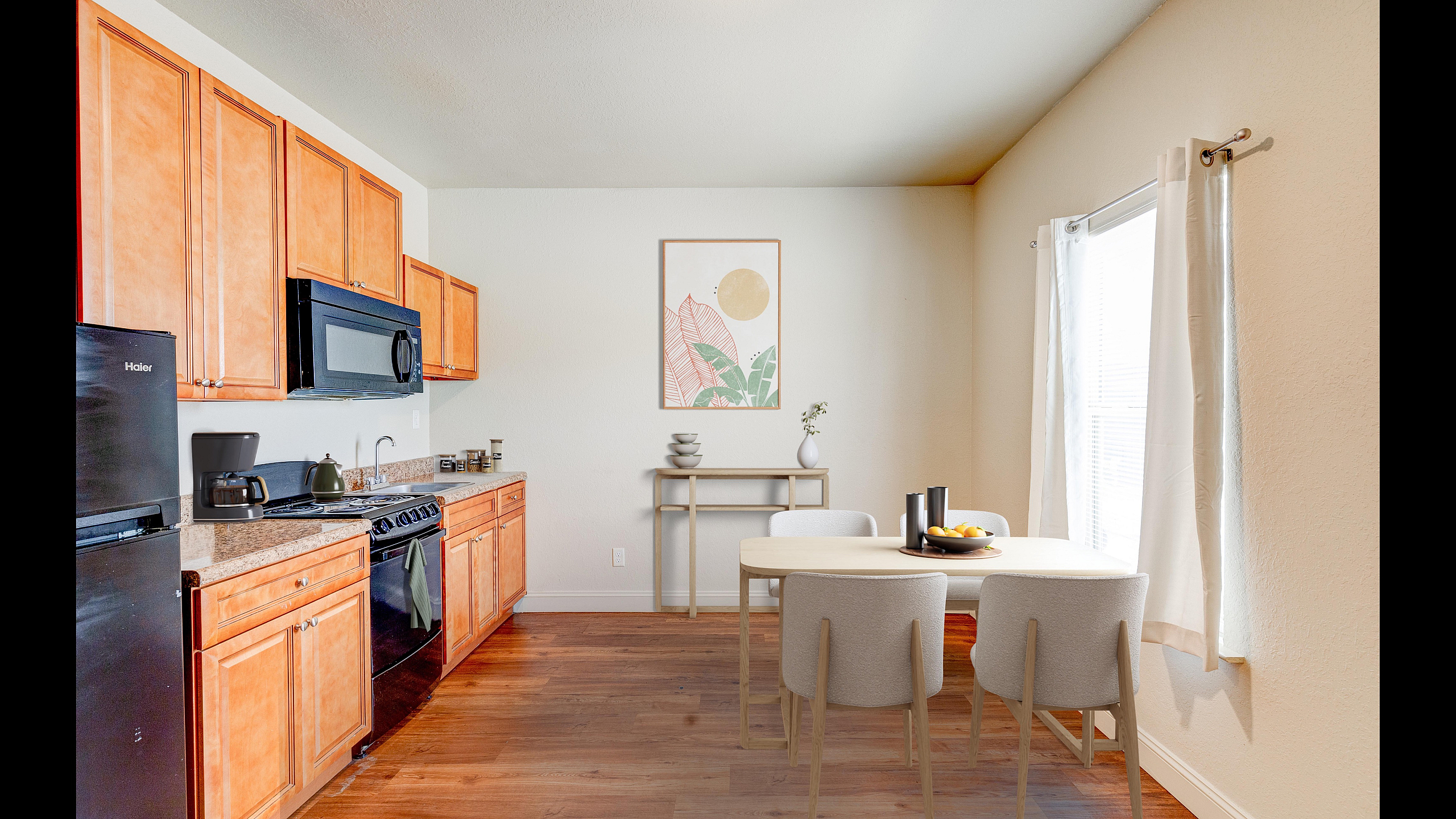 Inviting kitchen with warm wood cabinetry, sleek black appliances, and an elegant dining area filled with natural light.