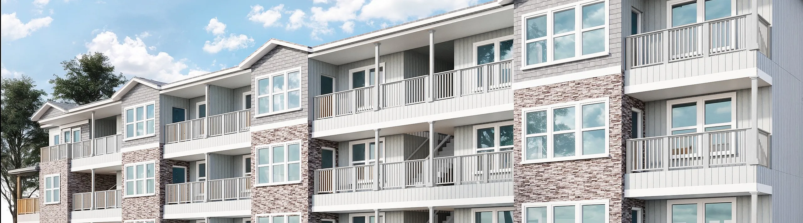Modern three-story apartment building with elegant balconies, large windows, and ample parking surrounded by a serene blue sky.